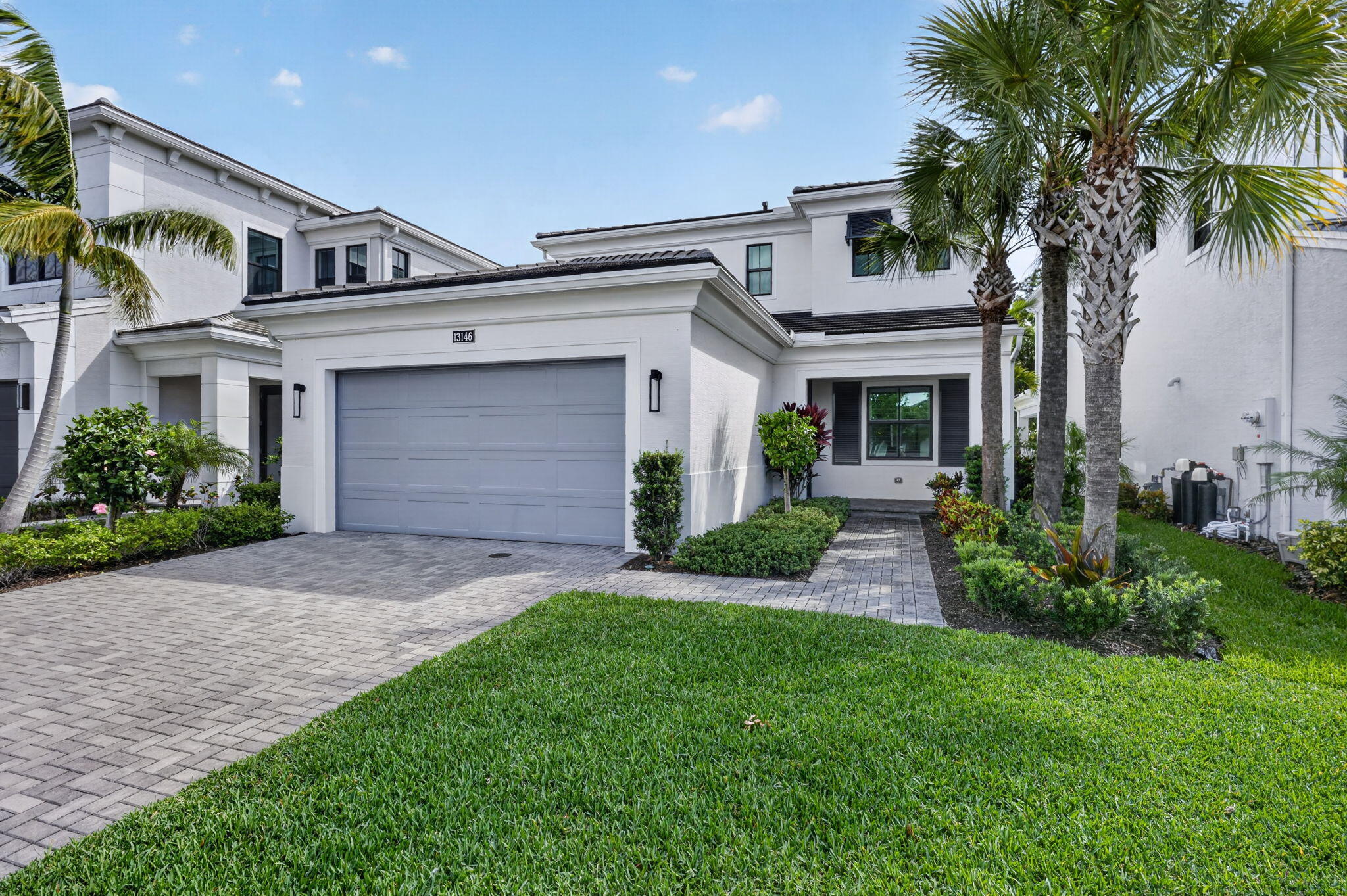 Beautifully designed "Francesca" model located in the highly sought-after gated community of Artistry in Palm Beach Gardens. This stunning residence showcases a bright and open layout with soaring ceilings, abundant natural light, and luxury finishes throughout, offering the perfect blend of elegance and comfort. The chef-inspired kitchen, with the kitchen 'waterfall' island layout option, features 2nd tier upper cabinetry with crown moulding, quartz countertops with full-height backsplash, and 48" Monogram gas cooktop. Kitchen seamlessly flows into spacious living and dining area, ideal for both everyday living and effortless entertaining. First-floor primary suite serves as a private retreat, complete with a spa-like bath featuring an oversized deluxe shower and expanded walk-in closet.  Thoughtful upgrades include under kitchen cabinet LED lighting, built-in wall oven, hardwood flooring, sleek stairwell with wood and steel balusters, and quality craftsmanship at every turn. The second floor includes 2 ensuite bedrooms, with a tub-to-shower conversion in the secondary bathroom, and loft area that provide versatility for guests, a home office, or den. Step outside to a private outdoor space with covered lanai designed for relaxation or entertaining, with a gas stub-out ready for a future pool heater or summer kitchen - perfect for embracing the Florida lifestyle year-round. An exterior tankless gas water heater adds efficiency and modern convenience.   Built by Kolter Homes, a highly regarded builder known for over two decades of experience, this residence reflects their signature "Built Around You" philosophy—offering thoughtful design, quality craftsmanship, and energy-efficient construction for lasting value. Homes in Artistry are constructed with modern building techniques and premium materials, often including impact glass, reinforced concrete construction, and smart, energy-conscious features designed for both durability and comfort.  Residents of Artistry enjoy access to a beautifully appointed clubhouse with resort-style amenities, including a pool, fitness center, and inviting social spaces, all set within a community known for its lush landscaping and tranquil surroundings.  Ideally located just minutes from premier shopping, dining, world-class golf, and only 3 miles to pristine beaches, this home offers exceptional lifestyle and convenience in one of Palm Beach Gardens' most desirable communities.