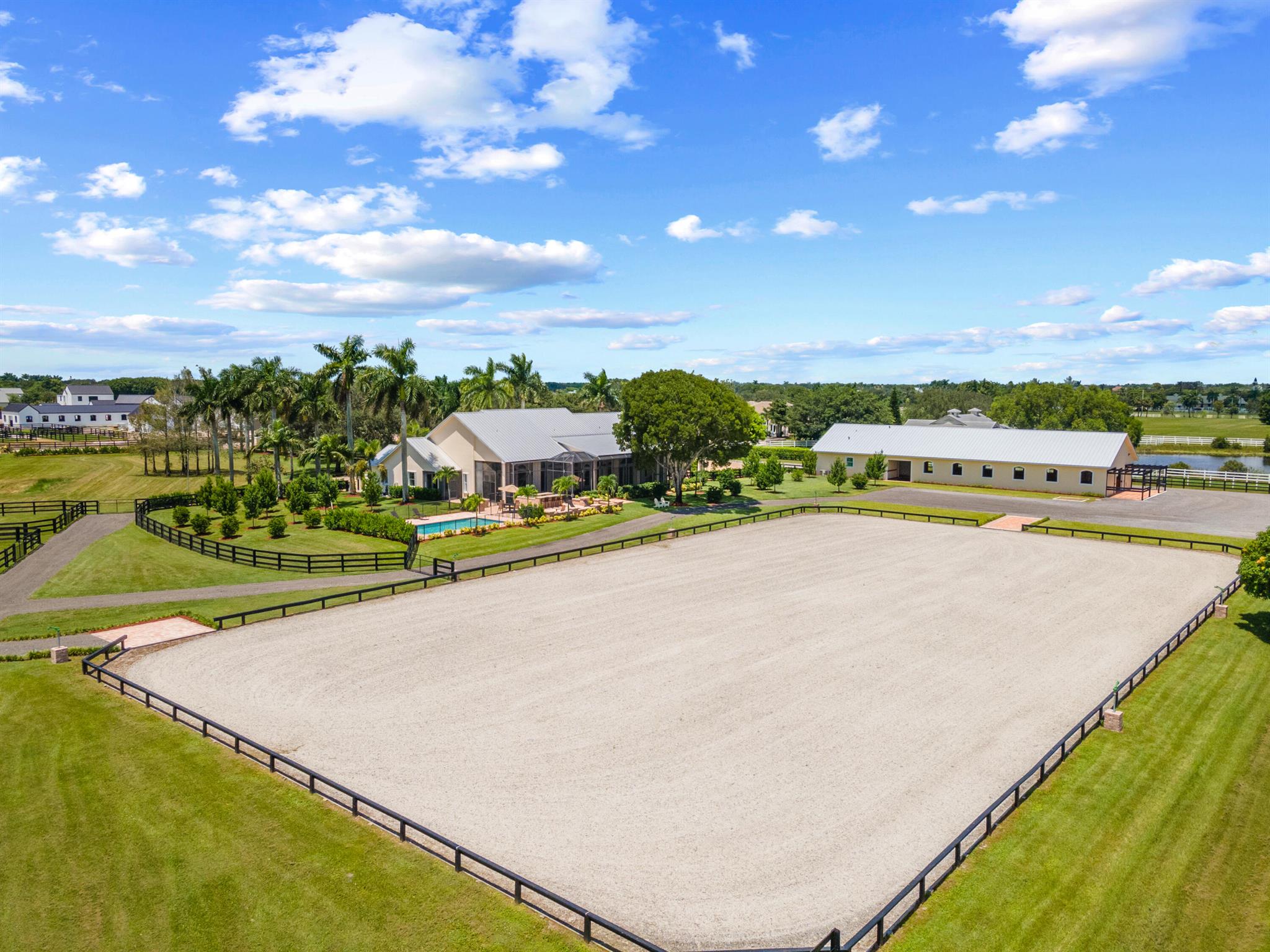 Great location close to the horse show grounds, within the elite gated community of Palm Beach Point. Recently completed, this  farm is ready for the upcoming season. New 12 stall center aisle barn by 5 Star Builders features a full wood tongue and groove ceiling, a 2-bedroom 2 bath staff quarters, feed and tack rooms, plus a ½ bath and Laundry, and is conveniently accessed by a separate entrance. A new all-weather arena with fiber footing, and six fenced and irrigated paddocks complete the equestrian facilities. Recently renovated the 5-bedroom 5 bath home features a new pool and outdoor grill area.  This ready to go farm sits on a roomy 6.4 AC lot at the end of a street, with a short walk to the horse show grounds. The mature landscape and lovely metal roofs on both house and barn, add to the ambiance of this well located property. Sellers are motivated...