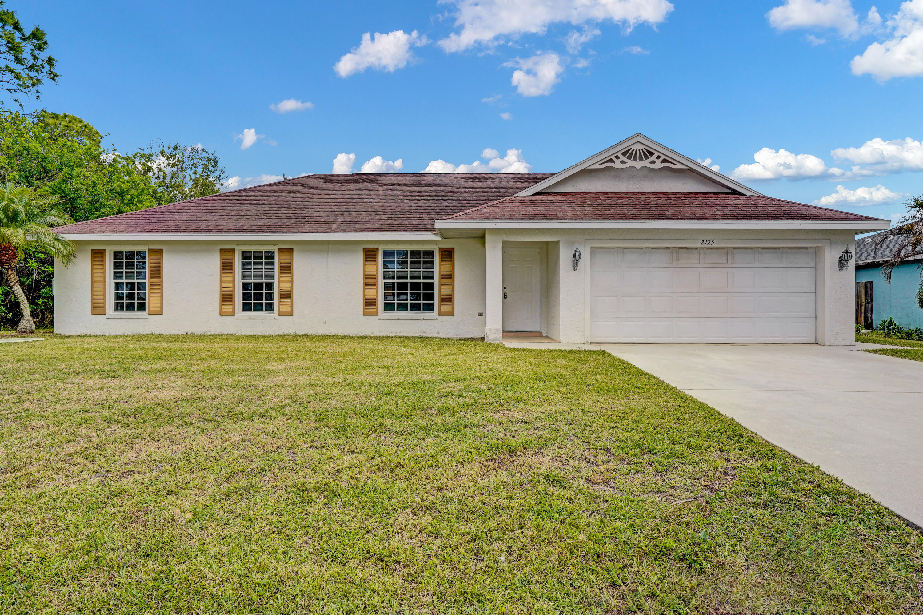 Spacious 4-bedroom home featuring a desirable split floor plan. The interior offers water-resistant vinyl flooring throughout, ceiling fans in each room, and window treatments for added comfort and style. This home is equipped with hurricane shutters for peace of mind. Enjoy outdoor living on the screened-in patio overlooking a nice-sized backyard. Conveniently located near I-95 and the Florida Turnpike for easy commuting. Property is being sold AS IS.