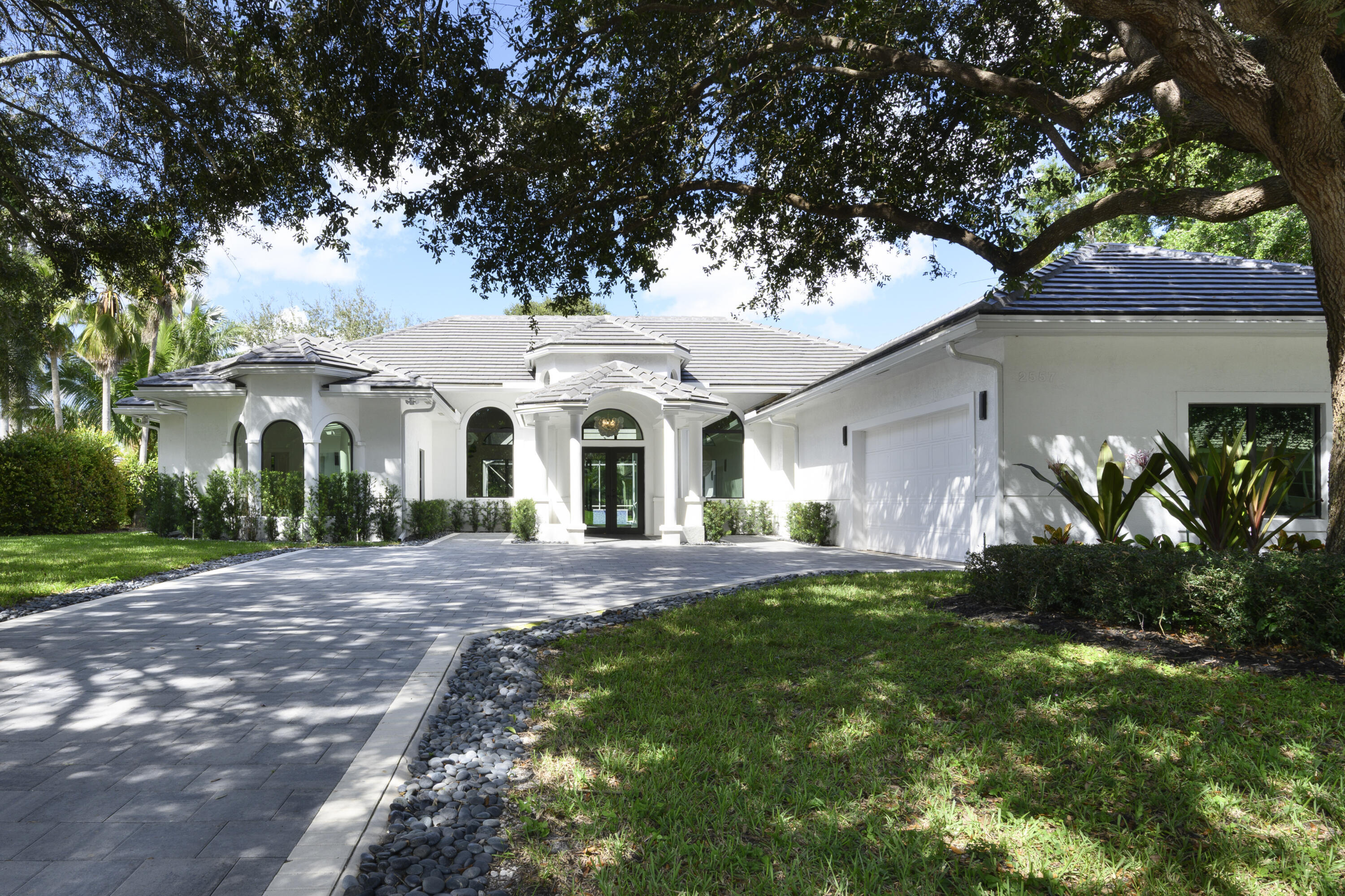 Experience the pinnacle of modern design and South Florida living in this completely reimagined residence, nestled on a quiet cul-de-sac within the prestigious gated community of Bear Lakes on Seminole Circle. Meticulously renovated with incredible features and upgrades, this 4-bedroom plus flex room (optional 5th bedroom), 4.5-bath home offers 4,505 square feet of luxurious living space designed for both everyday ease and grand entertaining. Step inside through a 15-foot foyer illuminated by a designer chandelier, leading into an expansive great room with 13-foot ceilings and sliders that open to a serene marble courtyard—creating a seamless indoor-outdoor connection. The heart of the home is a showstopping chef's kitchen featuring a 120+ inch waterfall island, quartz countertops with a full quartz backsplash, custom modern cabinetry, reach in pantry and a full Thermador appliance suite (2024). The primary suite is a private sanctuary with tranquil pool views, dual walk-in closets with custom built-ins, electric shades, and a spa-inspired bath with a soaking tub, oversized dual-head shower wrapped in large-format porcelain tile, and a 10-foot quartz custom dual vanity. Additional ensuite bedrooms offer comfort and style, while a versatile flex room serves perfectly as a gym or office. Recent enhancements include a new concrete flat tile roof, complete impact windows and doors, two inverter HVAC units, new modern driveway pavers, new upgraded screens and fresh interior and exterior paint (all 2024). Outdoors, enjoy resort-style living with a newly refinished salt-chlorinated pool finished with premium Florida Gem and glass tile, sandblasted marble pool deck, and a 2025 summer kitchen all surrounded by lush, private landscaping. Bear Lakes residents enjoy 24/7 security, low HOA fees, and access to three resident-only private parks with tennis, pickleball, and pool all minutes from premier golf clubs, fine dining, luxury shopping, PBI Airport, and the world-class beaches of Palm Beach.