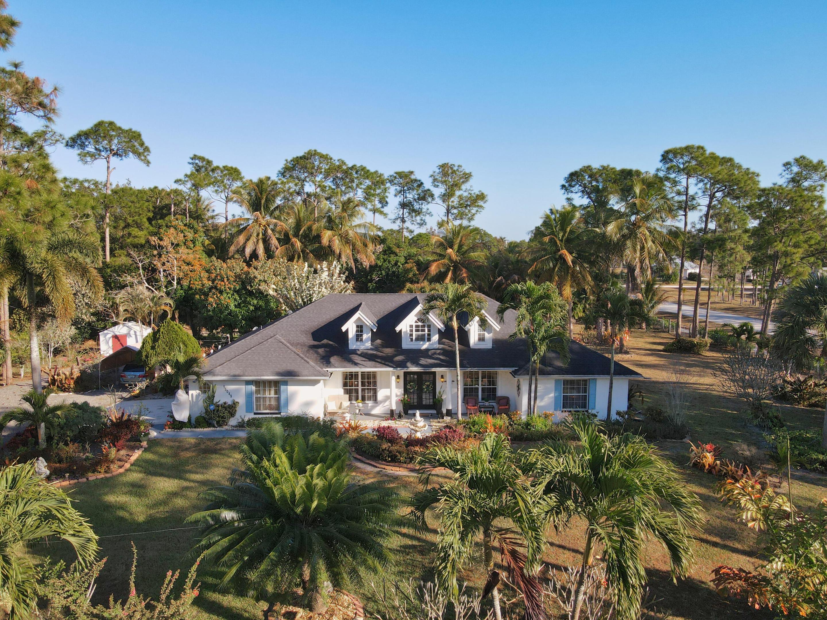 Welcome to peaceful country living in the heart of Loxahatchee, FL! Situated on 1.37 fully fenced acres with a private gate, this spacious 4-bedroom, 2-bathroom CBS home offers privacy, functionality, and freedom in an Agricultural Residential (AR) zoning area, with no HOA. Built in 1996 and offering 2,390 sq ft under air (3,098 total sq ft), this well-maintained home combines solid construction with meaningful updates that today's buyers appreciate. Major improvements include: Air conditioning system replaced just 1 year ago, Roof replaced approximately 5 years ago, Septic system pumped in 2023. Inside, you'll find a thoughtfully updated kitchen featuring solid wood cabinetry, generous storage, and plenty of workspace for cooking and entertaining. he home offers a comfortable split-bedroom layout, ceramic tile and carpet flooring, and a large 2-car garage. Step outside to a large covered patio and screened areas ideal for relaxing or entertaining year-round. The property is dotted with mature fruit trees including mangoes, June plums, coconuts, and more, creating your own private tropical setting. The fully fenced acreage provides room for boats, RVs, animals (per AR zoning), gardening, or future additions. A storage shed offers additional utility and workspace. Located in unincorporated Palm Beach County, you'll enjoy quiet rural living while still being conveniently close to shopping, schools, and main roadways. The water system is only 5 years new and has a reverse osmosis system for pure clean water. The air conditioning system is 1 year new. Water heater 3 months new. This property offers space, upgrades, and long-term durability a rare combination in today's market. The lot is very large. Add a Casita for aging parents or AirBnB.