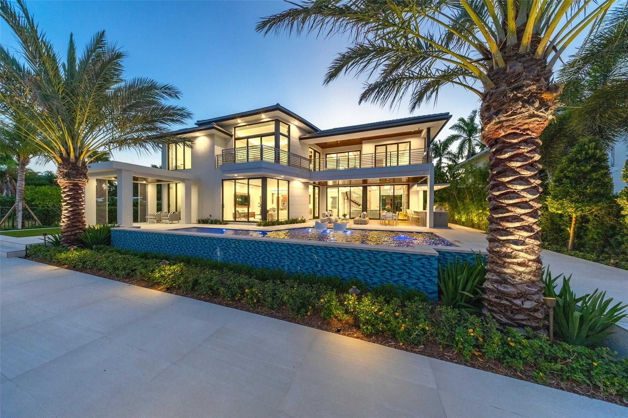 A statement of modern waterfront luxury, 24 Fiesta Way captivates with clean architecture, curated finishes, and 6,479 SF of refined living. Gated and private, this new residence rests on an 85' WF lot with beautifully designed landscaping and canal views. Interiors reveal custom veneered cabinetry, detailed ceiling carpentry, and expansive glass framing the courtyard. Features include Control4 system, shade pre-wiring, CCTV security, elevator with touchscreen controls, 48 kW generator, 1,000-gallon propane tank, tankless water heaters. Outdoor living boasts a loggia with BBQ, icemaker, refrigerator, and resort-style pool & spa. 5 beds + office, 5.5 baths, butler's kitchen, wine displays, concierge lounge with wet bar & wine fridge, primary suite with morning bar & spa bath, 3-car garage Driving Directions: Las Olas Blvd to Fiesta Way, property is on right