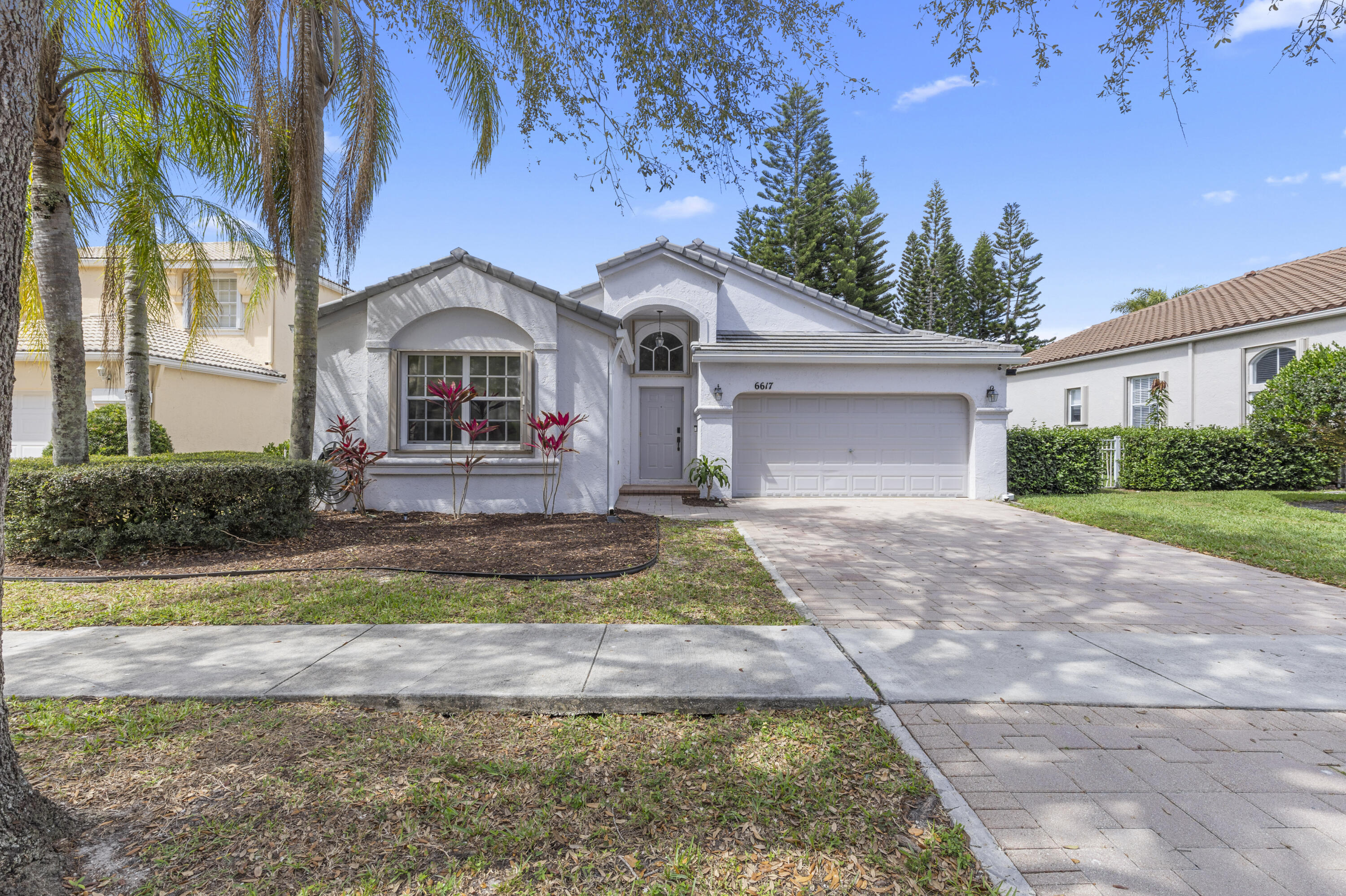 A brand-new tile roof installed in 2023 (approximately $40,000) adds tremendous value and helps to lower insurance costs, setting the stage for this beautifully updated lakefront home in the highly sought-after Smith Farm community. Located at 6617 Waverly Lane, this exceptional residence features over $120,000 in improvements completed within the past four years, seamlessly combining modern upgrades with everyday comfort. Offering 3 bedrooms, 2 bathrooms, and more than 2,100 square feet of living space, the home showcases waterproof luxury vinyl flooring throughout (approximately $12,000), updated baseboards, and fresh interior paint, creating a bright, stylish, and move-in-ready interior. The screened patio has been enhanced with low-maintenance organic turf (approximately $4,000). providing the perfect space for children, pets, relaxing, or entertaining while enjoying peaceful lake views. The fully renovated chef's kitchen is a standout feature, offering sleek European-style cabinetry, quartz countertops, stainless steel appliances, and abundant storage, making it ideal for both everyday living and entertaining. Both bathrooms have been extensively updated with modern vanities, designer mirrors, LED lighting, upgraded flooring, contemporary fixtures, stylish tile work, and a frameless glass shower enclosure that creates a luxurious spa-like feel. The guest bathroom was completely remodeled in 2025 with approximately $15,000 in improvements.  Additional upgrades include accordion hurricane shutters throughout, an impact-rated garage door, a Rheem water heater installed in 2020, and a well-maintained Trane air conditioning system. Custom blinds and elegant drapery add warmth and sophistication throughout the home. Outside, the spacious screened patio overlooks a premium lakefront homesite, providing the perfect setting for relaxing or entertaining while enjoying tranquil water views. The yard can also be easily fenced for additional privacy if desired. Ideally positioned near a quiet cul-de-sac, the property benefits from minimal traffic and a peaceful setting.  Interior enhancements continue with custom storage solutions, a GE washer and dryer, and over $8,000 in designer lighting, including a stunning Leighton Large Barrel chandelier, Augustine glass chandelier, and Goodman hanging lamp. Furniture is negotiable and available separately. The golf simulator in the garage does not convey with the sale.  This is truly one of the most extensively upgraded lakefront homes available in Smith Farm. HOA fees include cable and internet. Residents enjoy an outstanding location with top-rated schools, shopping, dining, major highways, and airports all nearby. Smith Farm is a gated community with two monitored entrances, video surveillance, and roving security patrols. Resort-style amenities include two swimming pools, a spa, kiddie pool, splash pad, playground, fitness center, tennis courts, racquetball courts, basketball courts, baseball field, and soccer field, offering an exceptional lifestyle for families of all ages.