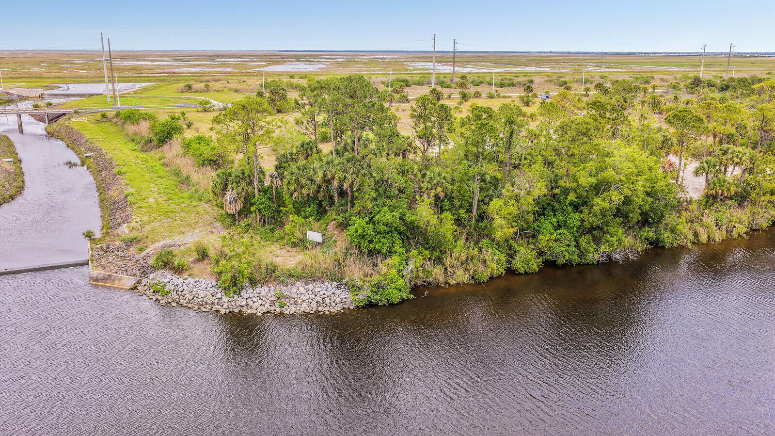 Set along 5+ pristine acres on the storied St. Lucie River, this exceptional parcel offers a rare opportunity to craft a private waterfront estate in one of South Florida's most tranquil natural settings. With 306 feet of riverfront and sweeping views of flush native landscape, the property invites a vision of refined coastal living shaped entirely by your imagination. From this remarkable location, enjoy navigable access both east to the Atlantic Ocean and west to Lake Okeechobee. The acreage provides an extraordinary canvas for designing a dream residence—imagine a grand waterfront home with sweeping terraces, a private dock, resort-style pool, and gardens that blend effortlessly into the surrounding environment. This is more than land—it is an invitation to create a legacy property.