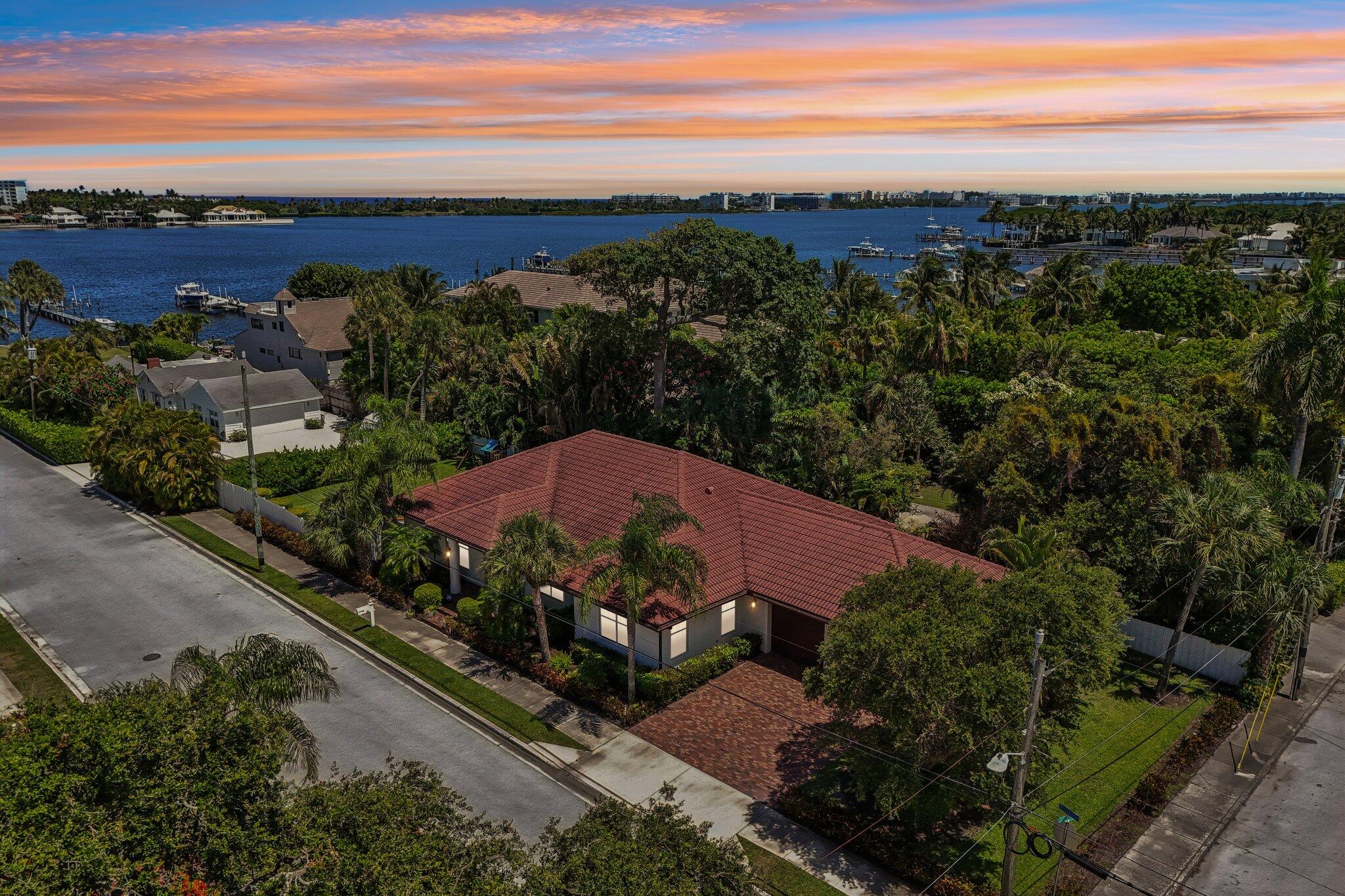 Completely renovated and move-in ready, this exceptional College Park residence offers the perfect blend of modern updates, quality construction, and an unbeatable location just one house from the Intracoastal Waterway. Situated on a private 10,018-square-foot corner lot, this 3-bedroom, 3-bathroom CBS home features 2,193 square feet of living space with soaring ceilings, an open-concept floor plan, and luxury vinyl plank flooring throughout. The beautifully updated kitchen serves as the heart of the home and is complemented by spacious living and dining areas designed for comfortable everyday living and effortless entertaining. Each of the three bedrooms features its own updated en-suite bathroom, creating a private retreat for family and guests alike.  The expansive 416-square-foot covered and screened patio extends the living space outdoors, while an elevated deck offers partial Intracoastal views overlooking the oversized fenced backyard with plenty of room to add a pool. Additional upgrades include a whole-house water filtration system installed in 2022, full impact glass windows and doors, central air conditioning, ceiling fans throughout, a sprinkler system, and a security system. Built in 2004 with solid CBS construction and a barrel tile roof, the home provides lasting durability and peace of mind. A rare two-car garage with additional golf cart storage adds convenience, while the quiet corner lot location just south of the West Palm Beach border places you close to waterfront living, dining, shopping, and all that Palm Beach County has to offer. This beautifully updated property combines contemporary style, modern functionality, and an exceptional location in one of Lake Worth's most desirable neighborhoods.