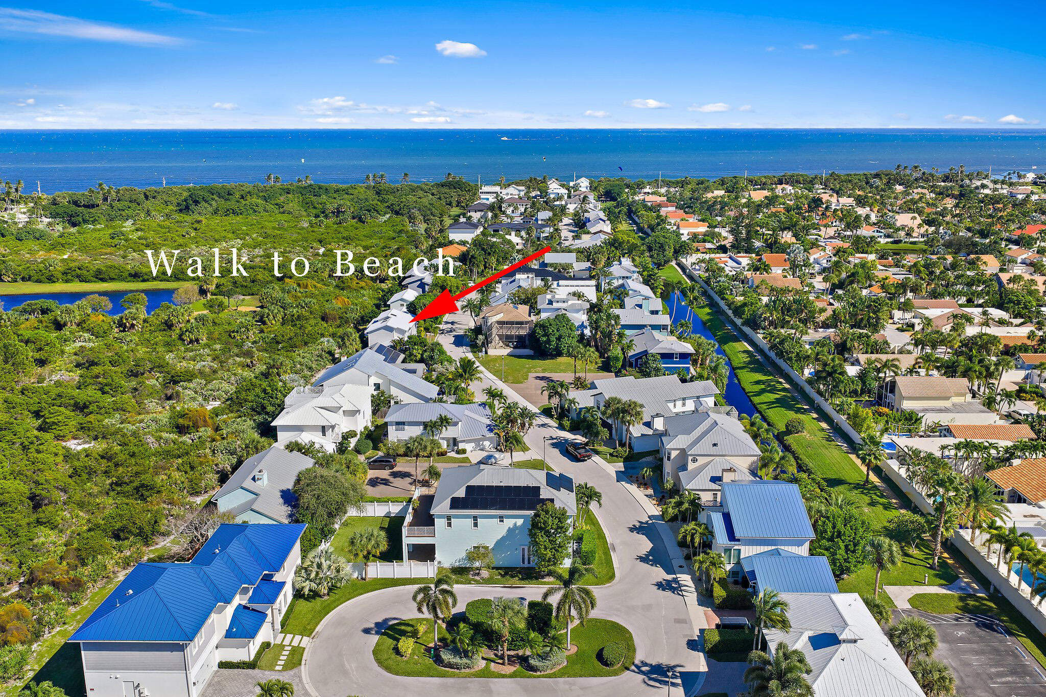 Walk to Beach! Nestled within the exclusive gated Jupiter Beach community of Xanadu by the Sea, this rare three-bedroom plus den home sits on one of the most desirable lots in the neighborhood, overlooking Carlin Park and the preserve beyond. Imagine walking to your favorite beach anytime you please & dog lovers enjoy a walk on the Jupiter Dog Beach.    The open-concept kitchen and living area flow effortlessly to a covered wraparound balcony with peaceful park views--perfect for morning coffee or evening dinners. Walls of sliders, and expansive windows fill the living space with natural light and showcase the surrounding greenery. The kitchen offers a large island, solid wood cabinetry, and generous storage. A private walkway provides direct access to Carlin Park, offering pickleball and tennis courts, an amphitheater, and a fitness trail. Jupiter's best restaurants and shops are just minutes away, and dog-friendly Jupiter Beach is an easy five-minute stroll. New Whole Foods is opening soon for pleasant shopping experience. This is coastal living at its best in one of Jupiter's most sought-after gated communities.The home features three bedrooms, a dedicated office or den, and three full bathrooms. The spacious primary suite includes dual sinks and a walk-in shower with frameless glass door. A private slider opens to the side yard, which is large enough to accommodate a pool. Pavers wrap around the rear of the home for easy maintenance.  Wood flooring runs throughout, and the oversized laundry room includes a dog door and access to the fenced yard, ideal for pet owners. The finished garage features an epoxy floor and ample space for bikes, kayaks, and even a motorcycle.  Additional highlights include impact-resistant windows, a new standing-seam metal roof, and fresh exterior paint completed in 2024.