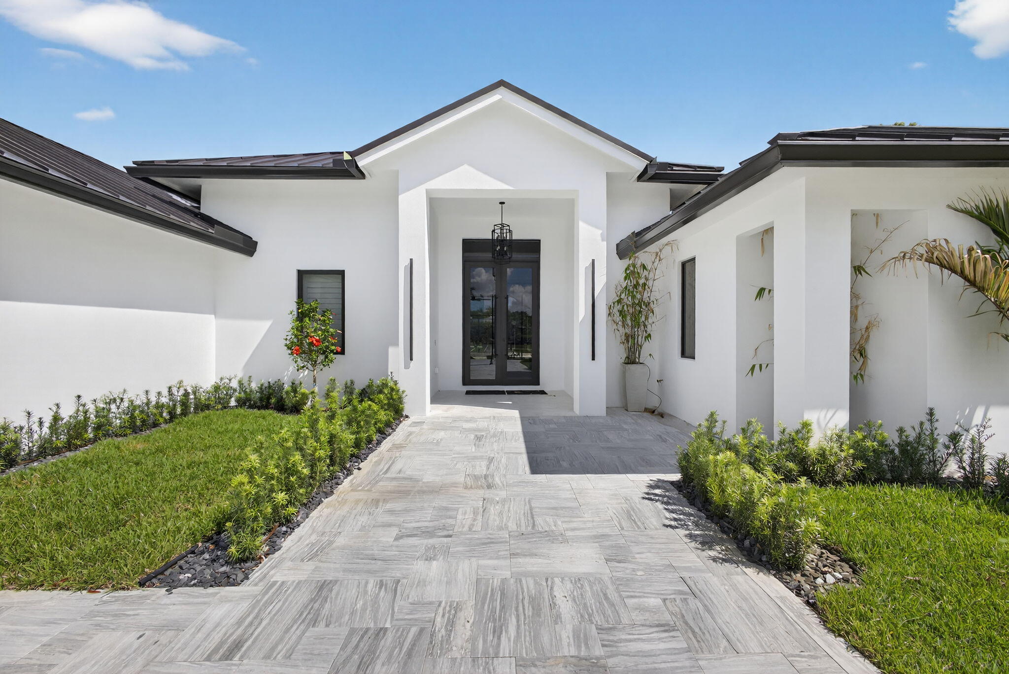 Completely reimagined, this custom-designed, newly rebuilt coastal style home in Steeplechase sits on a pristine 1 acre corner lot and lives like a brand-new luxury residence. This 4 BR, 4 bath home showcases sophisticated modern design, high ceilings, spacious rooms and a highly desirable triple split floor plan for ultimate privacy and comfort. Designed for effortless indoor-outdoor living, the spacious covered patio opens to a stunning new resort style pool, tennis courts, outdoor kitchen and beautifully landscaped grounds--creating the perfect, private retreat for entertaining or relaxing. Inside every detail has been thoughtfully upgraded with all new electrical, plumbing, high-end designer finishes, a Butler's pantry, coffee/tea nook, oversized laundry room. 24 hr security gate. This luxurious home has been rebuilt, from its 2026 metal roof, new septic system, new HVAC system--3 zones, all new high-end appliances, newly installed hurricane impact-resistant windows and doors to the new pool and outdoor kitchen, which are in the process of being completed. Estimated completion by end of June 2026. Epoxy garage floor is being done as well. Pavers will be added to the back patio and pool area. Large circular driveway and long driveway to garage constructed with Turkish marble pavers, to be used in the back patio and entire pool area. The pool photos and outdoor kitchen in this listing are renderings designed by the builder.