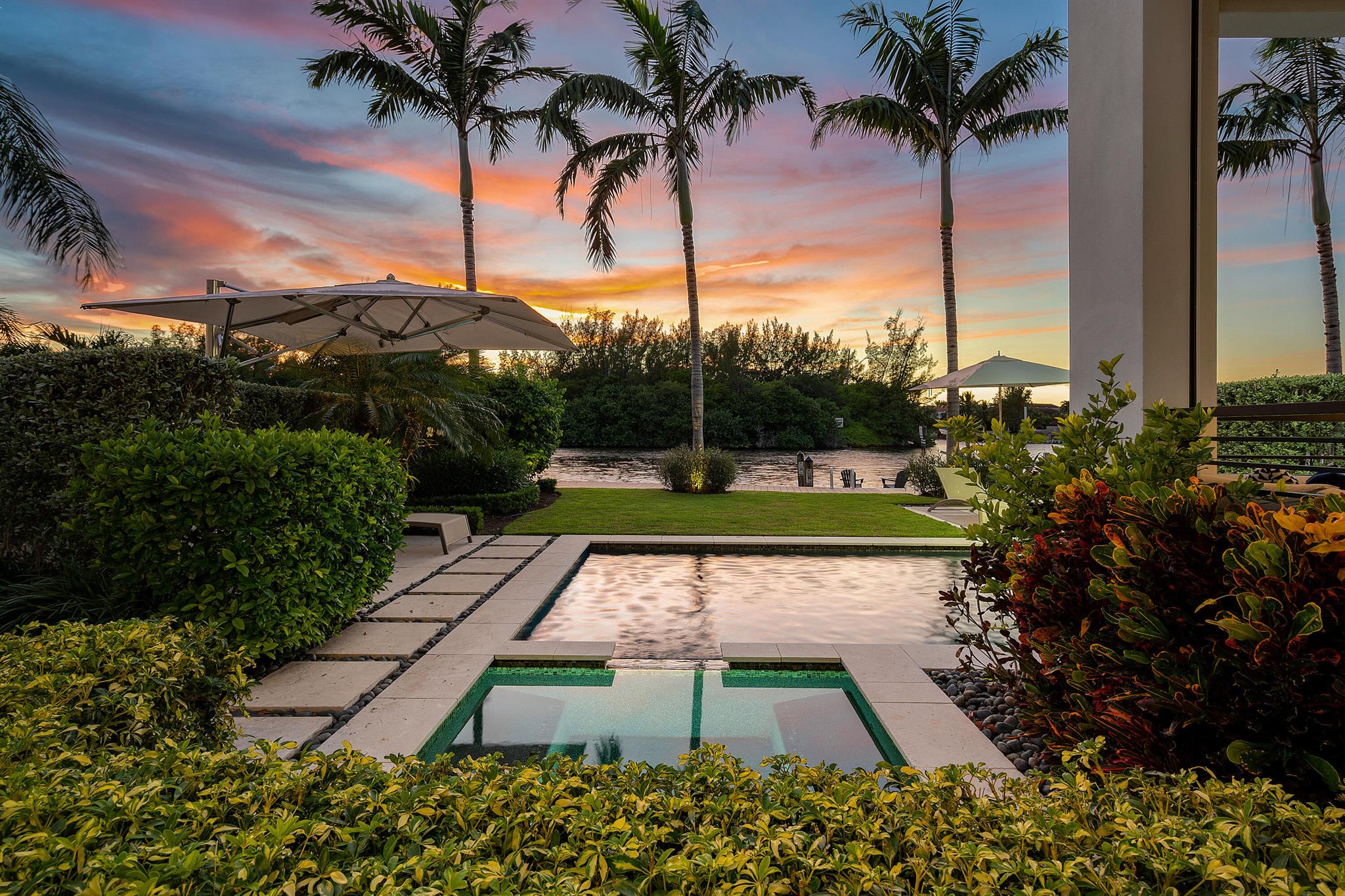 Discover a masterfully designed townhome that perfectly combines modern aesthetics with impeccable craftsmanship. Built by the esteemed National Custom Homes, this residence stands as a testament to superior quality and innovative design. Nestled in a prime location, the townhome boasts an unobstructed direct intracoastal view, offering an awe-inspiring vista that stretches beyond the horizon. With 40 feet of frontage, the property graciously accommodates a 36-foot boat, providing an exceptional opportunity for maritime enthusiasts.

Situated opposite a natural preserve, relish in the tranquility and be captivated by the beauty of endless sunsets that grace the horizon. Upon entering, you are welcomed by the grandeur of  12-foot+/- ceilings that sweep across the main living areas. Floor-to-ceiling glass panels seamlessly merge the indoors and outdoors, allowing the breathtaking surroundings to become an integral part of your living experience.

Luxury wood-like tile graces the floors, lending an air of sophistication to the interiors. The integration of cutting-edge technology enhances the home's allure, with full smart home capabilities seamlessly controlled by systems such as Control4 and Sonos. Phantom screens and electric shades offer both convenience and ambiance, ensuring a harmonious blend of comfort and style.

The townhome comprises four spacious bedrooms, three up and one downstairs. Each boasting meticulously designed built-in closets and en-suite bathrooms. These private retreats offer a blend of elegance and functionality, catering to your every need.

Ascend via the elevator to the VIP bedroom, a secluded enclave complete with an en-suite bathroom. Step onto the private balcony that presents sweeping views of the intracoastal waters, a personal sanctuary for moments of quiet reflection and rejuvenation.

For those who relish in outdoor living, the covered loggia beckons. This inviting space is perfectly suited for alfresco dining and entertaining, creating cherished memories with friends and loved ones.

Stepping into the backyard, you'll be greeted by a haven of leisure and relaxation. The private pool, complete with a soothing waterfall feature, becomes a focal point of serenity. The travertine deck exudes elegance while providing a perfect platform for sunbathing and socializing. A fully equipped, built-in summer kitchen caters to your culinary desires, making outdoor gatherings a delightful experience.

Boating enthusiasts will find delight in the 39-foot private dock, a mere 10-minute boat ride away from the Boca Inlet. This offers not just a practical convenience, but a gateway to endless aquatic adventures.

In summary, this modern contemporary townhome harmoniously blends exquisite design, technological sophistication, and natural beauty. It presents a unique opportunity to live life to the fullest, surrounded by elegance and comfort. Experience the allure of waterfront living and embrace a lifestyle that encapsulates luxury, convenience, and natural splendor.