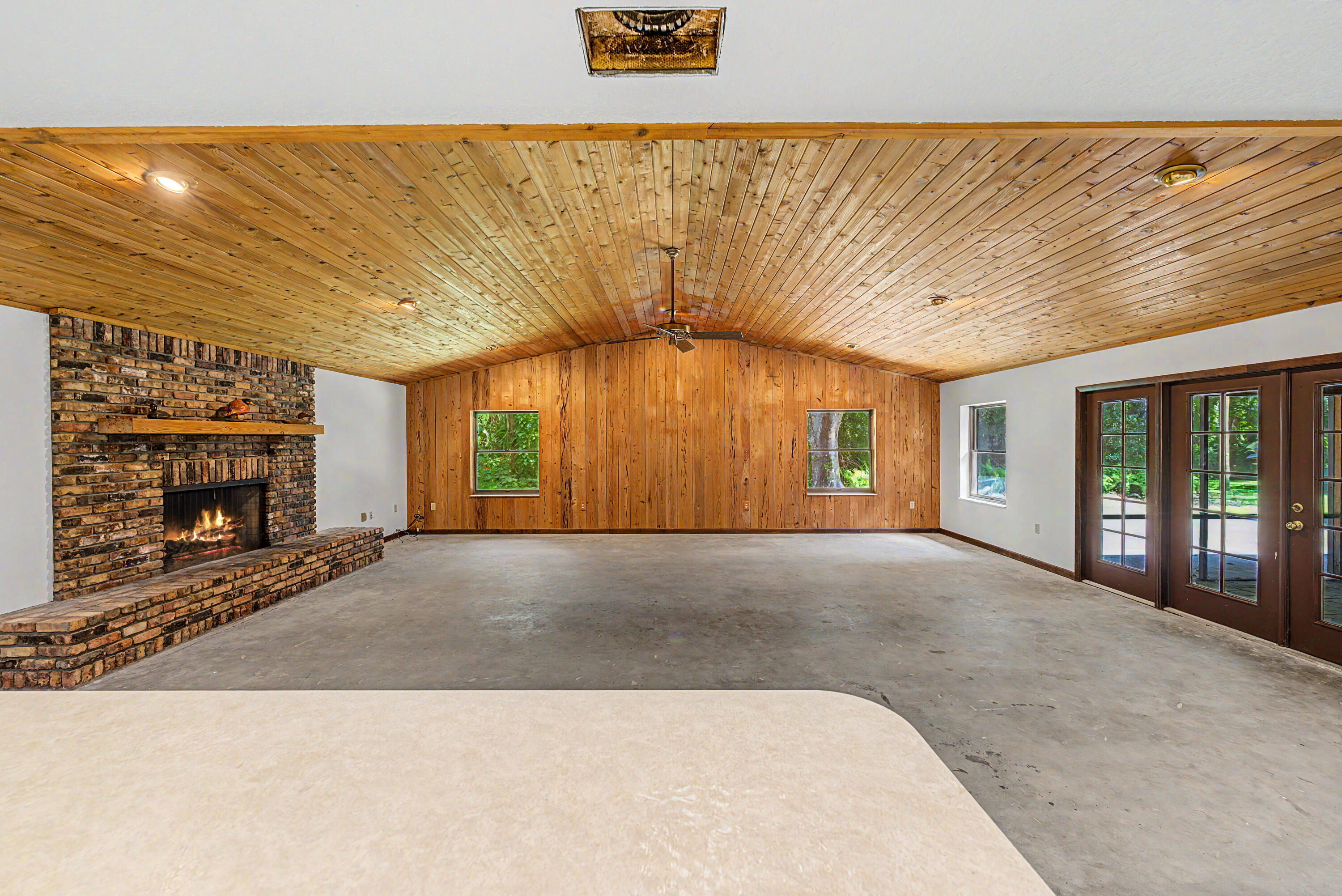 Just listed, this property offers the perfect blend of secluded country living and modern convenience. Situated in a natural Florida hardwood hammock on nearly 10 pristine, fully fenced acres with a private pond, the main residence features 3,884 sq.ft. of living space, 4 bedrooms, and 3.5 bathrooms. A massive 1,000-sq.-ft. great room is highlighted by rare Pecky Cypress wood, a brick fireplace, and a wet bar. French doors open to a screened patio, and a detached 1,720 sq.ft. 3-car CBS garage completes the package. Bring your choice of finished flooring to complete this vision! Located 9 miles from town and 30 minutes from Lake O fishing, with nearby hunting leases and abundant wildlife, this is truly a Sportsman's paradise.