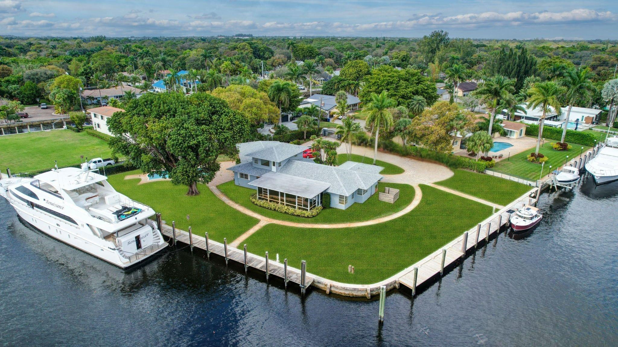 Valuable & rare point property under $4mm! Located in an idyllic & unique park-like setting opposite Secret Woods nature reserve & offering serene wide views on South Fork New River. Unusually large, .72 of an acre & perfect for large or multiple yachts, approx 344' of deepwater dockage, 191' on the river & 153' on side canal, approx 7.5 ft low tide depth. Residence is light & bright. New roof 2021. Offers expansive great room, dining area, kitchen & split bedroom plan 2 first level bedroom suites, upstairs primary & great views. In addition to 2-car garage there is a totally private Captain's quarters or guest suite. Enjoy as-is, renovate or tear down. Down River Estate is fenced & gated for privacy & security, vaste circular driveway, expansive green areas, established trees & large pool Property Details (as per seller) - Air conditioners replaced 2018 and 2022. Electrical main box and dock power 2009. Power on side canal dock 100 amp 220 v and river dock 100 amp 220v and 2 x 50 am 220 v.  Side canal width is approximately 100 ft.   Sprinkler pump and valves replaced 2024.  New gate motor & computer panel 2023.  Dredged in 2015  Seawall maintenance 2015.  New garage ceiling with tongue and grove in 2024.  Garage doors installed in 2024.  Septic tank approx 2 years old.