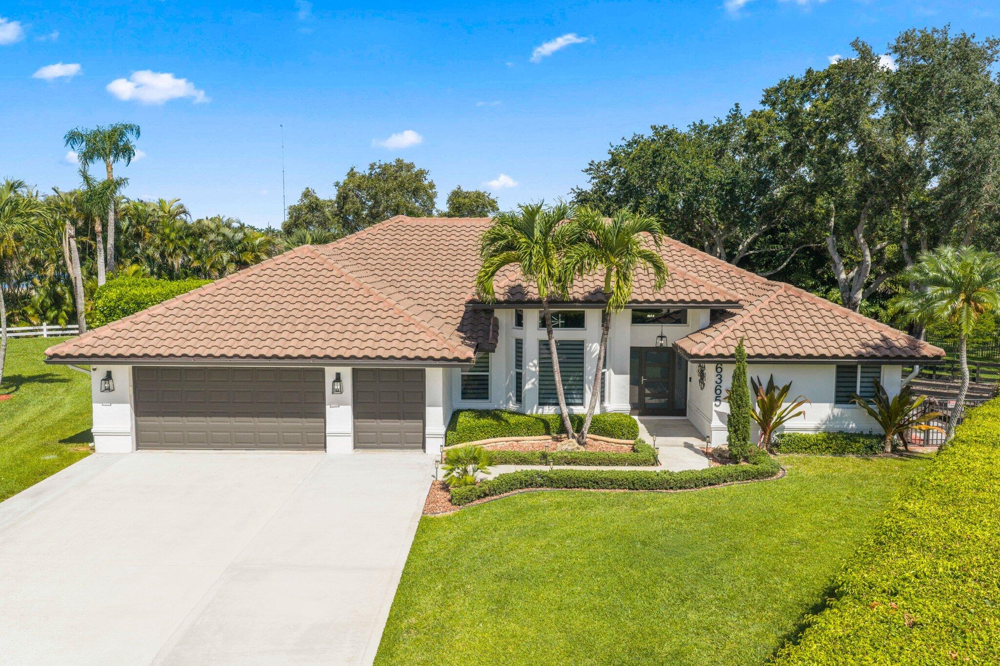 Modern luxury home in the gated community of Lacuna featuring 4-bedroom, 3-bath heated saltwater pool home offers the perfect blend of comfort, warmth, and functionality on an expansive .39-acre lot. Designed with a desirable triple-split floor plan, this ranch-style residence showcases soaring ceilings, crown molding, abundant natural light, and an open-concept layout ideal for both everyday living and entertaining. At the heart of the home, the stunning chef's kitchen features a grand oversized island, crisp white cabinetry, double oven, and elegant designer touches throughout. Fully outfitted impact windows flood the interior with exceptional light trimmed with extensive picture windows while framing the living space to peaceful views of the screened in pool and tranquil lake beyond. The bright and airy primary suite offers a true retreat with a spacious walk-in closet, spa inspired bath with dual vanities, a frameless glass shower and welcoming. soaking tub. Thoughtfully remodeled with care and attention to detail, this home reflects quality craftsmanship in every space.                   Throughout the home, vinyl flooring and tasteful finishes reflect meticulous attention to detail. Other things to note guest bedrooms generously sized. All guest bathrooms feature upgraded finishes with airy feels. Mud room with extensive storage and cabinetry,  Step outside to your private backyard surrounded by lush landscaping your own private oasis featuring a covered patio, cabana bath, fully fenced yard, playground, gardening area, and plenty of open green space for relaxing or entertaining. You do not want to miss out on this homes custom indoor-outdoor flow design. This residence delivers a serene effortless lifestyle.
