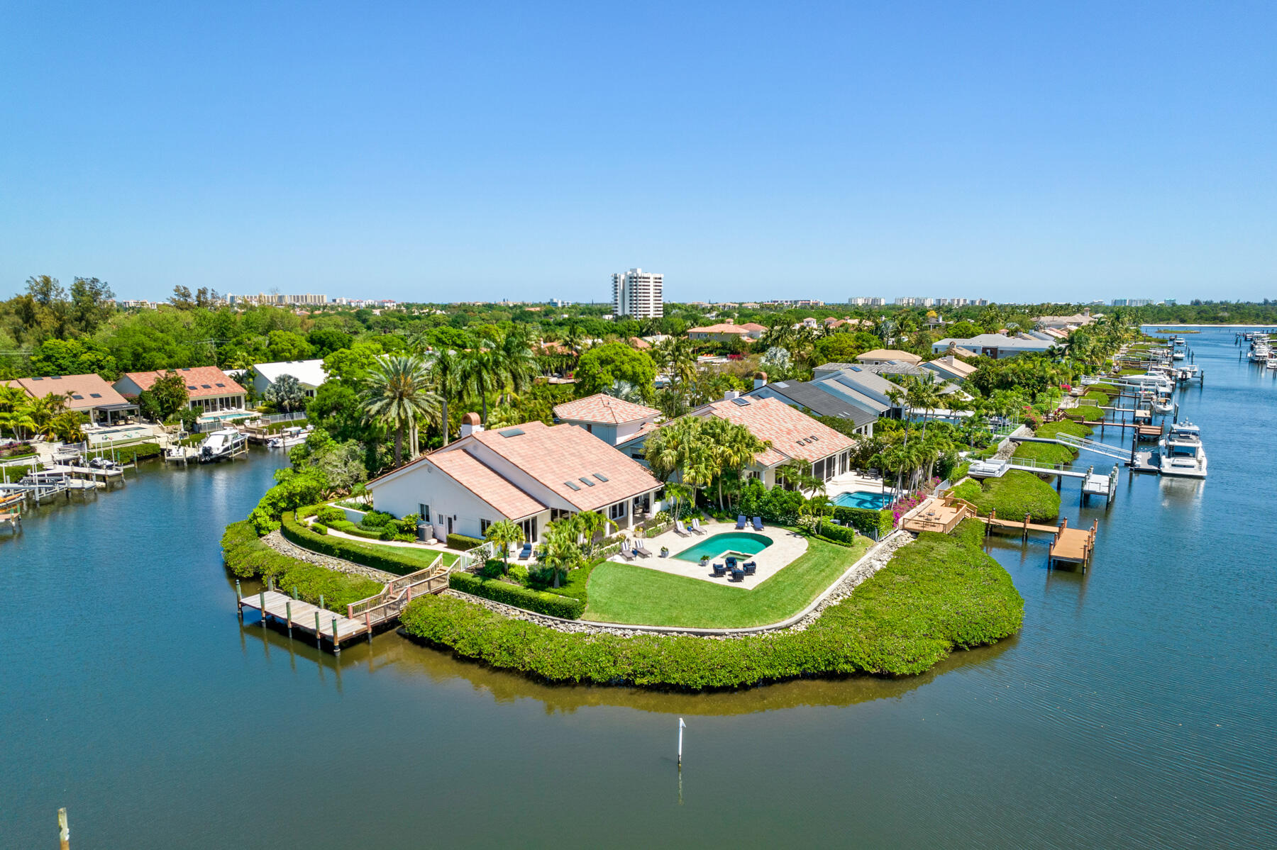 RARE OPPORTUNITY. Cul de sac location on private island. Totally reconstructed combining Modern Design and Neutral Palette. One story home on picturesque 1/2 acre POINT LOT W/300 FT OF WATERFRONTAGE. Classically timeless transitional open concept floorplan. Exceptional southwest sunset waterviews. 4BD/4.5BA/2.5CG. Close to intracoastal.  New expansive Travertine lanai/patio surround large heated pool/spa. Picturesque gardens. 9ft sliders let the outside in. French oak wood floors w/ herringbone pattern foyer. Soaring tongue and groove ceiling. A true chefs kitchen w/large pullout drawers, Carrara marble countertops, JennAir appliances, double ovens, 6 burner gas cooktop. Lutron Smart system. Floor to ceiling marble FP. Hollywood Regency Style Primary BR w/builtins. For features press more PRIVACY ABOUNDS
Open Concept Floor Plan

Impact Custom Glass and Gray Wood Front Door.

20 ft Tongue and Groove Ceilings

20 Foot Marble Encased Fireplace

Nine Foot Impact Sliders

Full Custom Closets Throughout

French Oak Wood Plank Floors

State of the Art Chefs Kitchen w/Rich Gray Custom Floor to Ceiling Wood Cabinetry by Cabinet Encounters Open to the Great Room.
Large Stainless Steel Sink, Jenn Air Contemporary Vent Hood, Double Jenn Air Ovens, 6 Burner Gas Cooktop, Built in Microwave, Bosch Dishwasher, and Extra Wide Pullout Drawers which Provide Sizable Storage.

Carrara Marble Kitchen Countertops with Two Tone White Backsplash

Custom Open Bar Designed By Grand Illusions with Ice Maker, Wine Refrigerator, Flanked by Two Tall Open Glass Display Cabinets for Crystal and Collectables.

Powder Room Boasts Pure White Micro-Crystaline Quartz Countertop Supported By French Fluted Polished Nickel Legs, Shimmering Walls of Silver Gray Metallic Paint, Contemporary Marble Inlay Floor, Sconces and Vintage Light Fixture.

Primary Bedroom with Burl Wood Hollywood Regency Built in Furniture, Plush White Carpet, Enormous Walk in Custom Closet and Additional Custom Storage Closet.

Luxuriously Appointed Primary Bath with Extra Deep Soaking Tub, Enormous Thassos Shower Wall, Intricate Marble Inlay Floor,  Regency Modern Custom Cabintry, Dual Kallista Sinks, Ralph Lauren Sconces, and Phylrich Brass Bath Fixtures.

Luxurious VIP Guest Bath with Seamless Shower Glass Barn Door and White Thassos Shower Wall with mosaic inlay. Suspended Contemporary Cabinet and Sink Framed by Solid Marble Wall. Thassos tiled floor.       

Guest Bathroom Two Boasts Full Marble Slab Floor, Seamless Shower Glass Barn Door, and Free Standing Vanity with Nickel Inlaid Accents, Pure White Micro-Crystaline Quartz Countertop and Polished Nickel Hammered Under Mount Sink. A Pair of Large Polished Nickel Sconces Frame French Silver Vintage Mirror.

Guest Bathroom Four includes Custom Built in Cabinet with Ultra Thick Gray and Black Veined Marble, Bianco Honed Marble Tile Floors and Shower With Black and Gray Veined Slab Shower Niche. 

Laundry Room w/White Glass Flooring, Electrolux Mega Capacity Front Loading Washer/Dryer, Custom Cabinetry, Blanco Composite Black Sink and Carrera Marble Countertop.

Sonos Surround Sound

Two Zone Trane A/C

New Hot Water Heater w/Recirculating Pump

Custom Sheer Window Panels 

Designer Light Fixtures

Second Level Buildout Opportunity to approximately 8000 Sq/Ft 
if Desired
