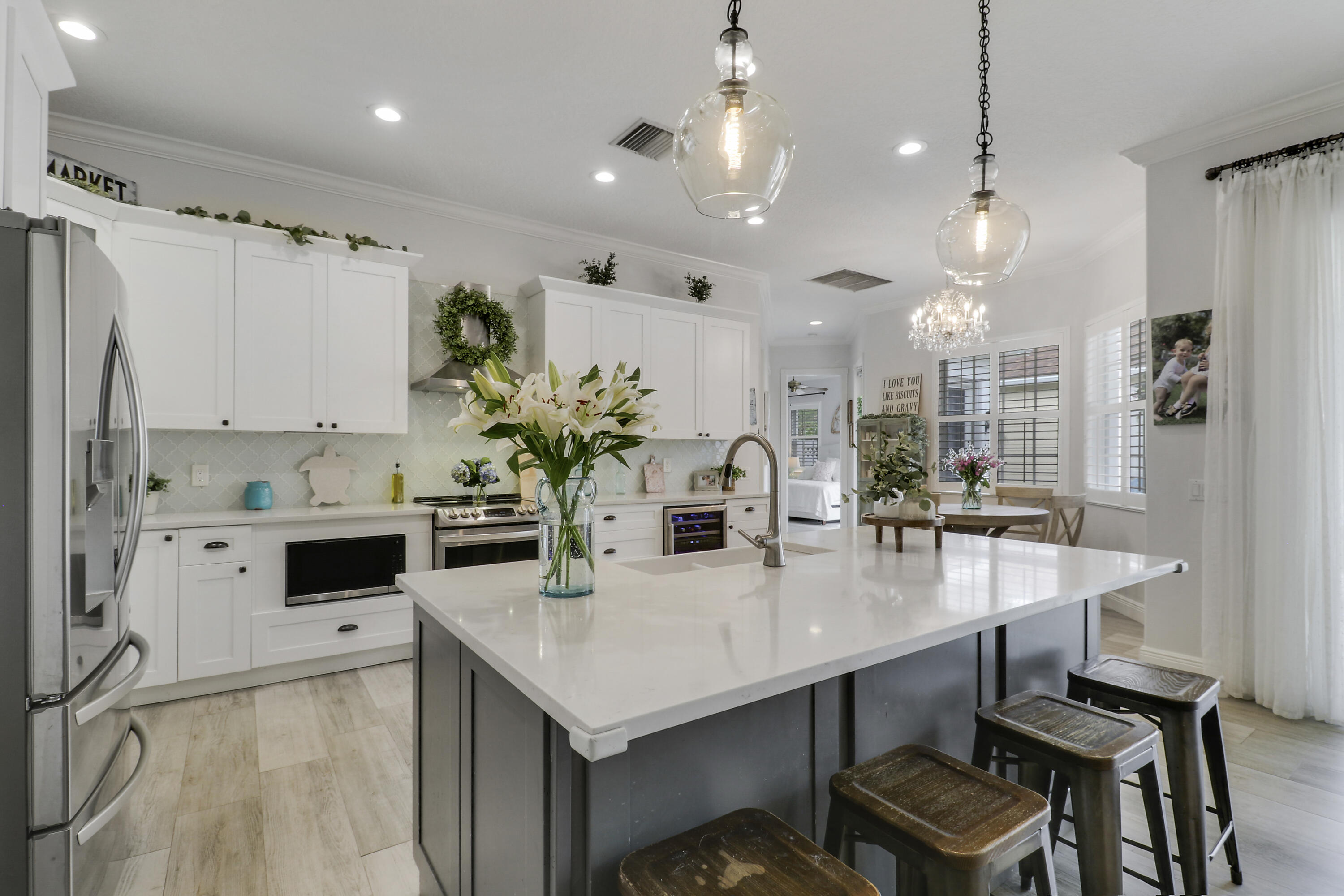 Bright, inviting, and ideally situated, this courtyard-style B-Model home in NewHaven at Abacoa—built by Divosta Homes in 1999—offers 3 bedrooms, 2.5 baths, and a 2-car garage, along with tranquil preserve views from its charming front porch. Inside, a thoughtfully designed open-concept layout features tile flooring throughout, plantation shutters, and a beautifully renovated kitchen that has been opened up to enhance flow and functionality. The kitchen includes a center island, quartz countertops, upgraded appliances, modern lighting, and a sleek glass backsplash. The spacious living area is perfectly suited for both entertaining and everyday living. The primary suite offers a true retreat, complete with a spa-like bathroom featuring quartz countertops and dual shower heads with handhelds & body sprayers for a luxurious experience. Step outside to a private side yard designed for low-maintenance enjoyment, featuring artificial turf and a fun mini putting green—ideal for relaxing or casual play. Recent updates: roof replaced in 2022,  4-ton A/C unit replaced in 2021 and primary bathroom remodeled in 2025, providing added comfort and peace of mind.  NewHaven is widely regarded as one of the premier neighborhoods in Jupiter, consisting of 405 single-family homes and 100 townhomes, and offering a true sense of community. Residents enjoy a well-maintained environment with HOA benefits that include exterior painting (completed in 2025), cable TV and high-speed internet through Hotwire, exterior pest control, and landscaping. Community amenities include two pools with heaters for the winter months and chillers to keep them refreshing in the summer, a brand-new fitness center, 2 playgrounds for the kids, clubhouses, scenic walking trails, and a newly added covered park. All just minutes from pristine beaches, top-rated schools, golf, shopping, dining, downtown Abacoa, and Palm Beach International Airport.