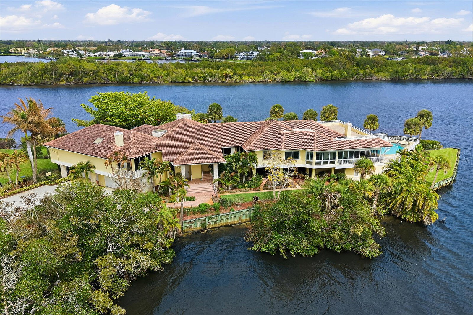 Seller Says Sell — Priced More Than a Quarter Million Dollars Below Recent Certified Appraisal !!! The Peninsula Estate is gracefully set upon more than an acre of land with approximately 650 feet of extraordinary water frontage, offering one of the most private and captivating waterfront settings along Florida's coveted Treasure Coast. Positioned on a rare peninsula within the exclusive gated community of Bay St. Lucie, the property is surrounded by sweeping panoramic views of the St. Lucie River, creating the feeling of a secluded island retreat. The residence encompasses over 8,467 square feet of refined living space, thoughtfully designed to capture the beauty of its surroundings. Elegant marble flooring, expansive living and   river vistas from nearly every room, seamlessly connecting the interior spaces with the serene waterfront landscape. A separate guest residence offers private entertaining areas, a gourmet kitchen, and a distinguished library with fireplace reflect both comfort and sophistication. Walls of glass frame spectacular accommodations ideal for extended family or visiting guests. The estate's expansive grounds and remarkable peninsula setting present exceptional possibilities for a private family compound, executive retreat, or luxury waterfront sanctuary. Outdoors, private docks with 30,000 lb. and 10,000 lb. boat lifts and a resort-style pool overlook the tranquil waters of the St. Lucie River, completing this extraordinary waterfront offering. The Peninsula Estate represents a rare legacy property where privacy, scale, and natural beauty converge. Additional details and property information available in the MLS.