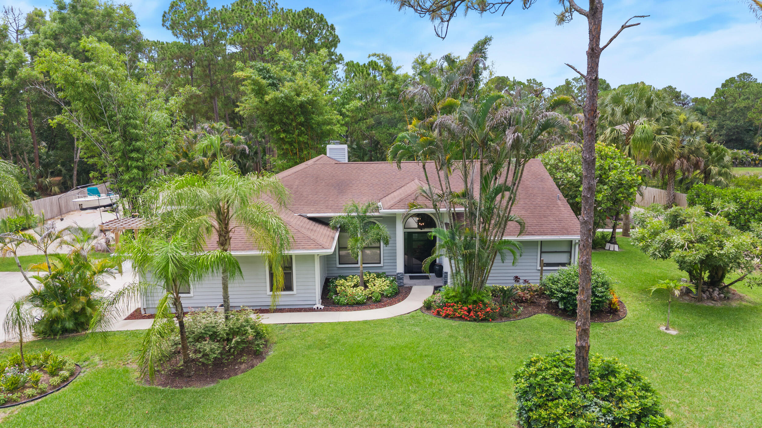 Beautifully updated 3-bedroom, 2-bath home with a 2-car garage situated on 1.25 beautifully landscaped acres with no HOA. Designed for those who need space to live, work, and play, this property features a rare wraparound driveway that makes pulling in, parking, and storing boats, RVs, trailers, campers, work trucks, and all your recreational toys effortless. A hurricane-rated storage shed provides secure space for equipment, tools, and outdoor gear, while the partially fenced property with gated access offers added privacy and convenience. Inside, the open kitchen flows seamlessly into the spacious family room, where a cozy fireplace creates the perfect gathering space. A separate formal living and dining room provides endless flexibility and can easily be transformed into a home office,  media room, game room, or additional living space.  Step outside to your own private backyard oasis featuring a sparkling pool, lush tropical landscaping, and a custom outdoor bar—perfect for entertaining or unwinding after a long day. With ample room to expand, add a detached garage, workshop, guest house, or create the outdoor paradise you've always envisioned, this move-in-ready property offers endless possibilities. Enjoy the freedom of acreage living without sacrificing convenience, with beautiful beaches, shopping, dining, and everyday essentials just minutes away. This is the Florida lifestyle you've been looking for.