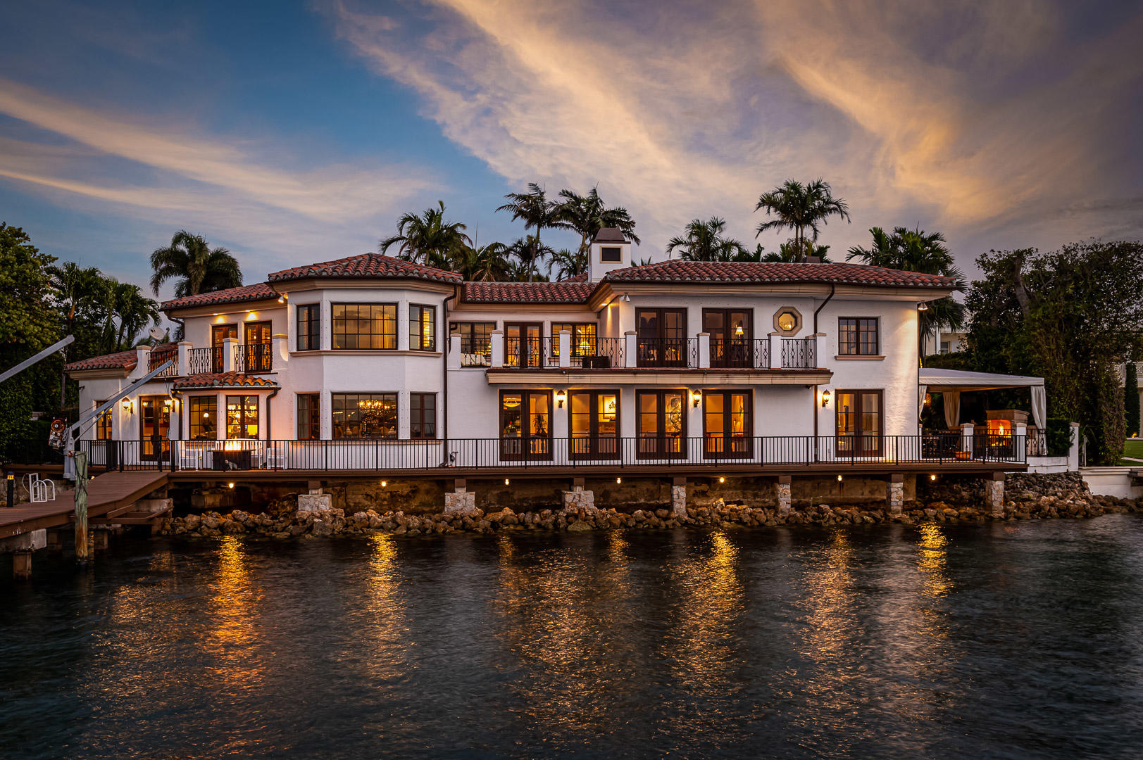 Magical estate compound, ¾ acres hidden on the north end with 133 feet of direct intracoastal frontage sitting directly on the water with deep water dock. The property is made up of three separate buildings with a total of 9 bedrooms, all en suite plus 3 half baths. The uniqueness of this property cannot be overstated. Built in the spirit of ''Old Palm Beach'' this house is of a size that is easily manageable and has the feeling of home. The grounds are landscaped in a way that creates a tropical garden. It is truly magical.

 When you are thinking location, location, location please keep in mind that this house is perfectly located with NO Bike Path in front of the house which means NO strangers walking or riding bikes past your private residence. What a great asset. A reminder also is that the house is not in any airport flight path and when you get on your boat, you are only a few minutes to pass through the Palm Beach inlet and out to the ocean.

Upon entering through the beautiful wrought iron door, you can't help your eyes from looking down the path to the main house, through the glass wrought iron front door and out to the glimmering waters of the intracoastal waterway. The water is crystal clear because you are located so close to the Palm Beach inlet which leads directly to the Atlantic. In less than five minutes you can be cruising along the eastern seaboard.
The walk from the front entry way and following the path leading down the stunning landscaped path to the main house is truly a walk of serenity. The main house with 4 bedrooms upstairs and water views from every room makes this home truly unique. The views from all downstairs rooms feels like you are sitting on the bow of a ship. Stunning by day, magical by night with the water view lights twinkling across the lake from dusk until dawn.
This compound is breathtaking. As you walk out the front door of the house and back up the path you first come upon the venetian fountain which serves as a focal point of the property. When you turn north, you head towards the oversized pool 36'X17' up two steps. The pool shade awning sitting area at the east end of the pool looks west to the pool and over the Bellagio Fountains streaming into the deep blue tile pool.
Back to the fountain and walking the path south brings you to the Pool Cabana which can easily service as a Studio guest apartment or a fitness room.
Once again returning to the fountain you can walk back west towards the front where you entered and will be at the Guest House which includes two large Master Suites upstairs and downstairs on the north side and on the southside is the oversized 3 car garage, (4 cars if you have your Maserati) and two more guest suites upstairs for a total of 4 large bedrooms.
There are so many aspects to this "Estate Compound" which make it so special. There are special rooms and spaces, inside and out where catching your moments of peace and serenity can be found. There are three waterfalls around the property serving as ideal places to reflect.
This property has what we all want. A place which we can call all our own. The quietness of the north end can be felt. The fragrance of tropical flowers waft in the air. The breezes from the intracoastal one day will be replaced by the ocean breezes the next.
There are three balconies upstairs in the main house. One on the east side and two on the west looking over your magnificent views as boats making their way through the intracoastal gently move by.
Well maintained with loving care this spectacular property is waiting for you. As a personal testimony, there are many wonder houses in Palm Beach, but we have never seen one that reveals such understated elegance.