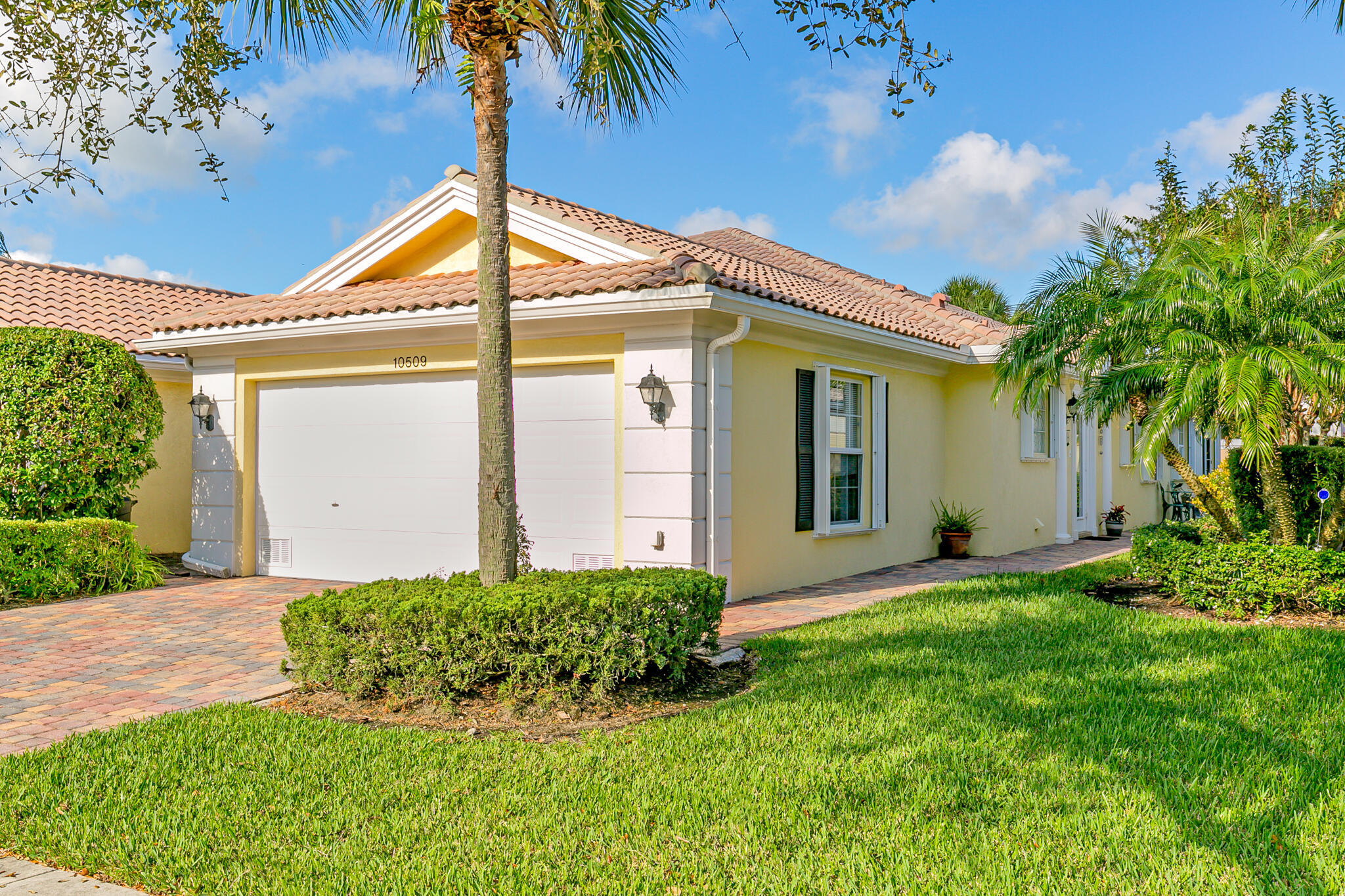 Welcome to this charming cottage-style 2-bedroom, 2-bathroom villa, ideally located within walking distance of Downtown Tradition. Meticulously maintained and move-in ready, this inviting home features a new A/C (2026), new LG refrigerator & stove (2026), designer kitchen, wood & tile flooring throughout, plantation shutters, & tasteful updated lighting fixtures.  Relax & unwind in the enclosed Florida room overlooking the beautifully landscaped, private backyard gardens. Enjoy the safety of whole house accordion shutters as another turn key feature. The highly inclusive HOA offers true turnkey living, covering full clubhouse amenities, manned gated entry, lawn care, cable, internet, & even exterior painting of the villa, scheduled for this fall. This villa has it all!