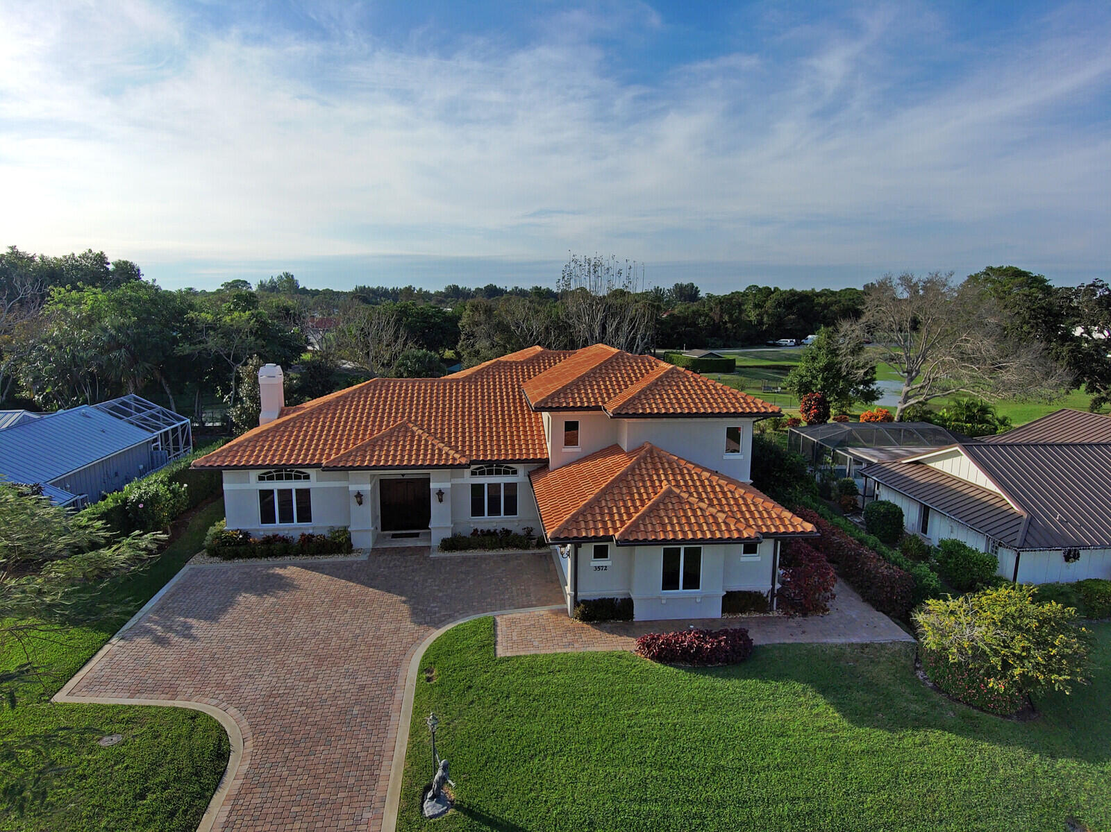 Welcome to 3572 SE Court Drive, an exquisite home located in the prestigious Yacht and Country Club of Stuart (YCCS), offering a luxurious lifestyle with a 24-hour manned gate security entrance and OPTIONAL social and golf memberships. This custom-built estate home, completed in 2016, boasts oak wood floors throughout, a stunning gourmet kitchen, 9-13' coffered ceilings, custom fireplace, a private elevator and temperature-controlled wine room. The residence features a master suite on the first floor, complemented by three additional bedrooms plus a den/office, 3.5 baths plus an oversized 2 car garage and pavered driveway. Security and energy efficiency are assured with impact windows, walk-in temperature-controlled attic spaces with an abundance of insulation, a 500 gallon propane tank, 2 propane instant hot water heaters and a full house generator that provides peace of mind during power outages.

The gourmet kitchen is a chef's dream, featuring wood cabinets, high-end stainless steel Jenn Air appliances, and beautiful natural stone countertops. Bathrooms also showcase the elegance of natural stone countertops.

Outdoors, this estate sits on an expansive quarter-acre lot (approximately 0.287 acres), boasting high elevation, privacy in the rear with park-like views of a green area, grassed surroundings, and mature trees. A beautiful stone-floored balcony upstairs provides a private retreat and a perfect vantage point for enjoying the surroundings. Downstairs, a screened covered patio with beautiful stone flooring extends the living space outdoors, creating an inviting area for relaxation and entertainment.

The property is a short walk to the community pool, tennis and fitness center, croquet, and more (social membership required to use amenities). The community itself offers 24-hour security, a beautiful golf course, driving ranges, a full restaurant and bar, close proximity to all necessities, lots of social activities, and waterfront properties.

This meticulously maintained and thoughtfully designed estate is an exceptional residence for those seeking a harmonious blend of luxury, comfort, and convenience. Seize the opportunity to make 3572 SE Court Drive your dream home by contacting us for a private showing. Discover the unparalleled lifestyle that awaits you in this exquisite property.