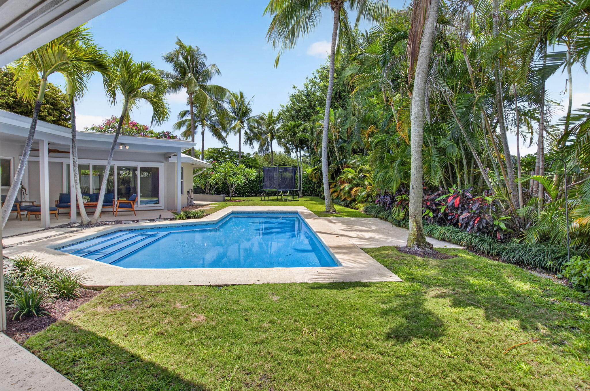 Exceptionally renovated and meticulously maintained, this stunning one-story residence in sought-after Lake Ida / Lake Shore Estates truly has it all. Perfectly positioned on a private .35-acre cul-de-sac lot, this home offers the ideal combination of luxury, comfort, and functionality with 4 bedrooms or  a spacious den/office, and 3 full bathrooms. Adding to its unique appeal, the home was originally designed by renowned late Delray Beach architect Roy Simon for his brother, reflecting the legacy of a designer known for several notable local landmarks.  From the moment you enter, you'll appreciate the quality craftsmanship and thoughtful upgrades throughout, including porcelain tile flooring, smooth-finish walls, impact windows and doors, and a full-house generator for complete peace of   mind.  The heart of the home is the spectacular chef's kitchen, featuring custom solid hickory center island topped with quartzite, elegant two-tone cabinetry, dual sinks, two Wolf ovens, a Wolf induction cooktop, and a stunning hammered copper farmhouse sink. A convenient pass-through window, abundant natural light, and direct views of the sparkling blue pool create the perfect indoor-outdoor lifestyle.  The spacious primary suite serves as a private retreat with direct access to the patio and pool area, tranquil backyard views, a custom walk-in closet, and a beautifully designed ensuite bath complete with a walnut double vanity and oversized frameless glass shower.  A substantial den/office/media room addition provides exceptional flexibility, whether working from home, hosting movie nights, or creating a playroom. Two additional guest bedrooms and two full guest bathrooms offer ample accommodations for family and visitors.  Step outside to your own private backyard oasis. Fully enclosed for privacy, the outdoor space features a beautifully renovated pool completed in 2026, lush green lawn areas, and abundant room for entertaining, all enhanced by desirable southern exposure.  Boating enthusiasts will appreciate the unique oversized garage design featuring dual garage doors that allow for easy drive-through access. A dedicated concrete boat pad with a custom wood-framed cover provides protected storage for your boat and toys, a rare and valuable feature.  This move-in-ready Lake Shore Estates gem offers exceptional upgrades, versatile living spaces, and an unbeatable private setting—an extraordinary opportunity to enjoy the very best of Florida living.