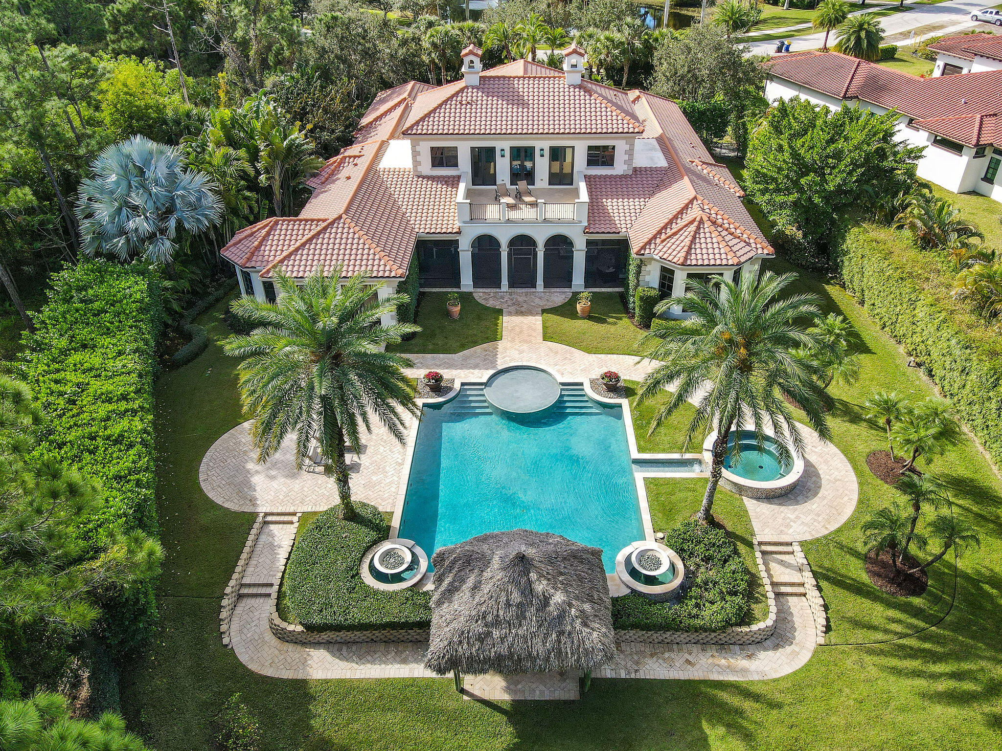 Rarely available custom estate home situated on 1.05 acres in the gated community of Hidden Bridge Estates comprised of only 16 homes. This luxurious home with the finest of finishes built by Onshore Construction offers 5 Bedrooms, 5 Full Baths, 2 Half Baths, Den, Movie/Media Room, 3.5 car garage for the most discerning buyer. Hight ceilings and tall hurricane impact glass doors and windows allow natural light to illuminate throughout.  A welcoming formal living room with cozy fireplace awaits you as you enter the beautiful custom door to the home. A newly renovated gourmet kitchen with spacious island, Wolfe range, oven, microwave, Bosch dishwasher and Subzero refrigerator. Butler's Pantry and wet bar area and separate wine cellar room. Generous size primary suite located on 1st floor with 2 walk-in closets and a brand new high-end custom bathroom just completed with dual vanities, two water closets, separate walk in shower and tub. 2nd en-suite bedroom, den, movie/media room, and formal dining room also located on 1st floor. 2nd floor includes three en-suite bedrooms, great for family or guests rooms. All bedrooms include walk-in closets creating plenty of storage. 2nd floor balcony connects two of the three bedrooms and holds plenty of room for lounge chairs to relax and enjoy serene backyard and pool views. Enjoy a spectacular resort style heated salt-water pool/spa, swim up to the seats attached to your very own tiki hut in a private sprawling backyard with lush landscaping. Screened in loggia with plenty of room for covered outdoor entertaining and a brand new Wolf gas grill. Other new home features include: two Rinnai tankless hot water heaters, whole house generator with automatic load sharing switch for HVAC systems, 4 zone HVAC system, two Pentair variable speed pool pumps, central vac system, updated light fixtures, security/fire alarm system, sprinkler system on irrigation well, separate golf cart garage perfect for extra storage for tools & equipment or maintenance entrance. Long circular driveway hosts plenty of room for parking for gatherings and privacy. Conveniently located close to nature preserve, Jupiter community park and sports fields, shopping, I-95, Turnpike, beaches and Jupiter lighthouses and fine dining.  This grand, elegant residence is truly a state-of-the-art masterpiece and leaves nothing to be desired. Your custom sunny South Florida home in paradise awaits you!