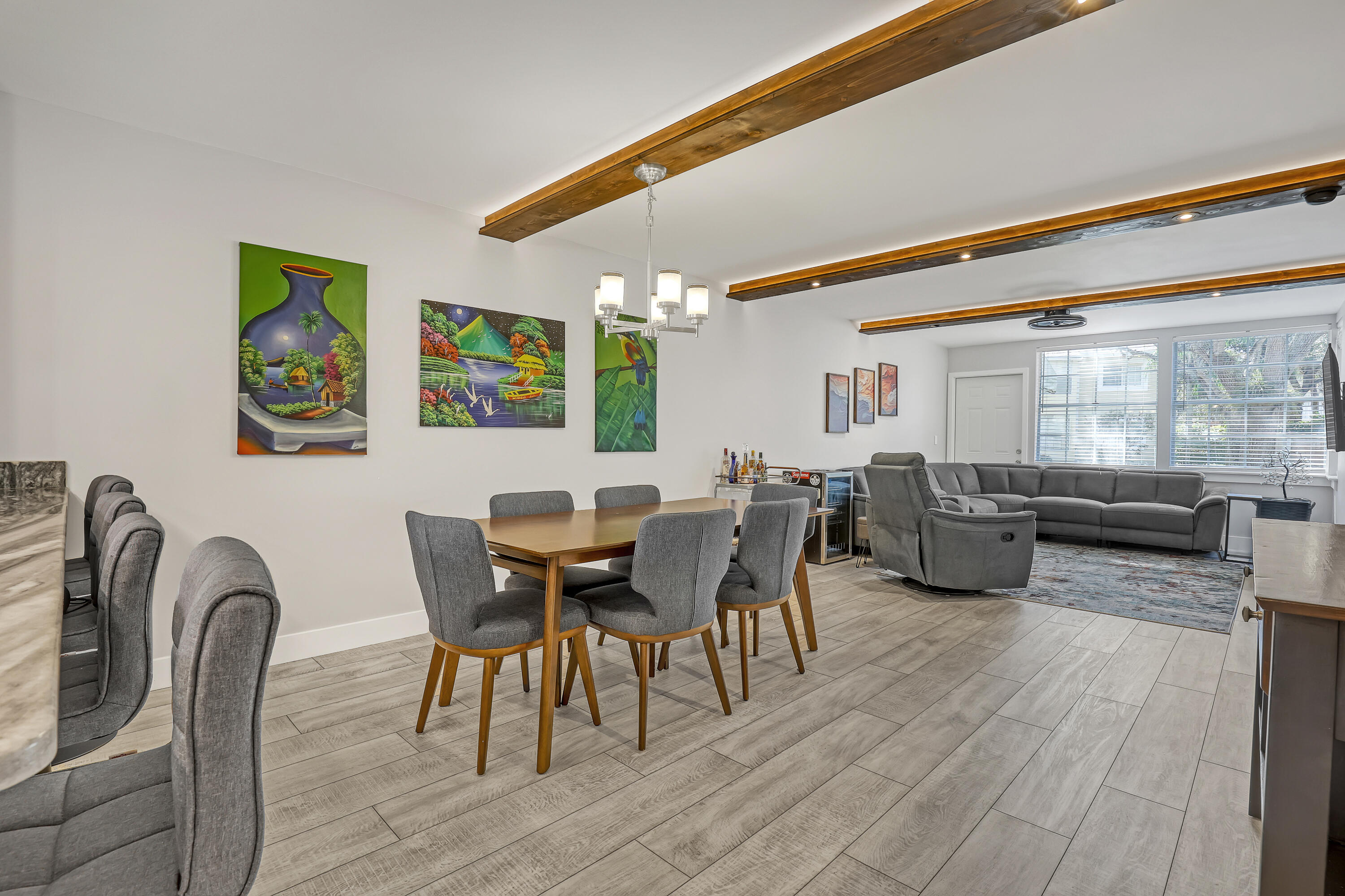 Welcome to this beautifully updated, light-filled corner unit with thoughtful upgrades throughout. High ceilings with exposed beams feature indirect LED cove lighting and recessed lighting, creating a warm, modern ambiance. The updated kitchen offers stainless steel appliances, granite countertops, and a spacious island, perfect for everyday living and entertaining. A split-bedroom floor plan provides added privacy, while luxury vinyl flooring runs throughout for a clean, cohesive look.  The primary suite features an updated shower with bench, quartz countertops, and an LED mirror. The guest bathroom has been tastefully updated with a modern tile surround and quartz countertops. Major improvements include a new roof (2025), A/C only a few years old, and all air ducts and dryer ducts replaced. Ideally located near the front of this quiet, well-maintained community and just steps from the association pool, with shopping and dining nearby, this move-in-ready condo is easy to love.
