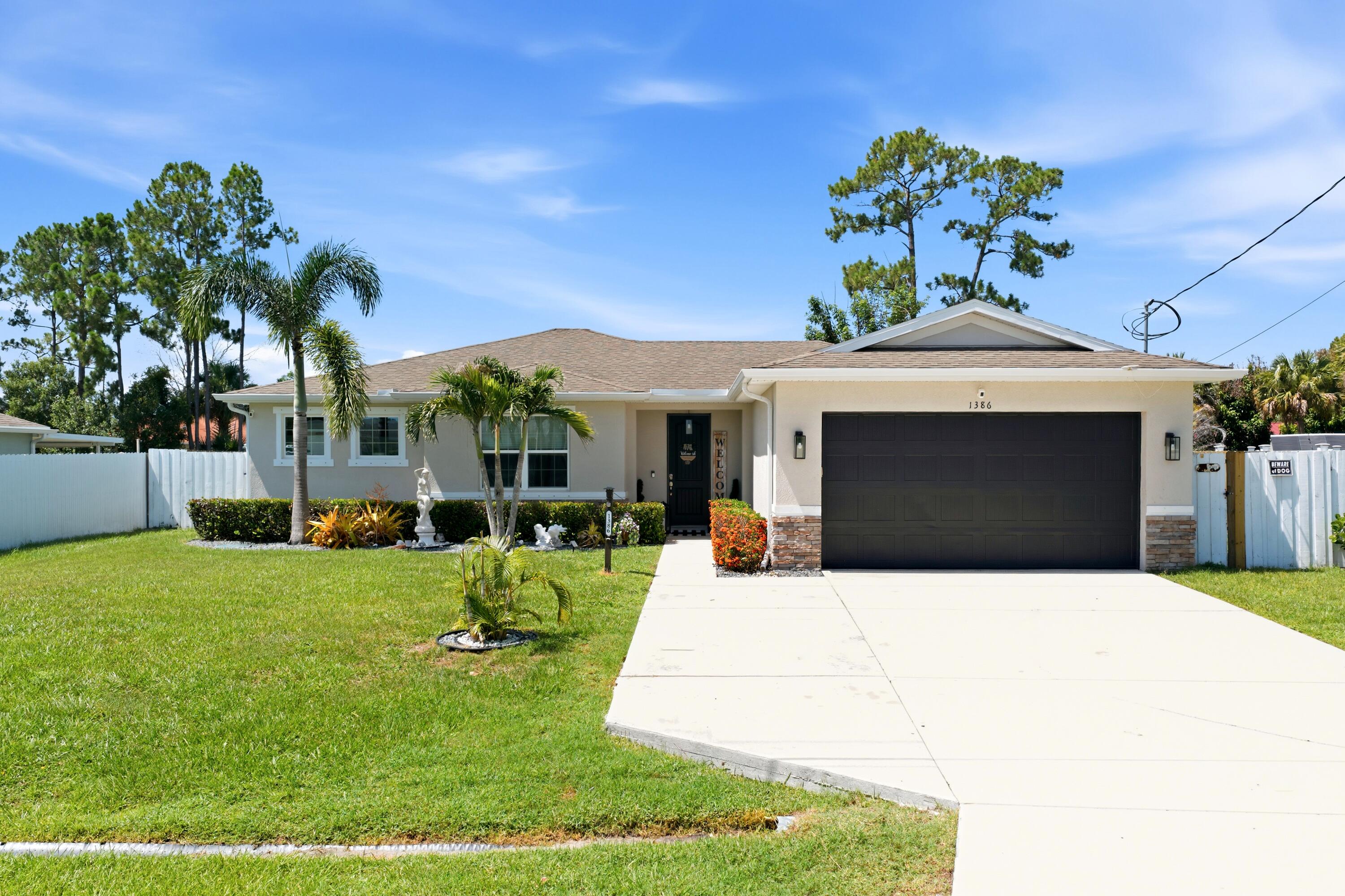 Built in 2019, this well maintained 4-bedroom, 2-bath home with a 2-car garage offers a thoughtfully designed split-bedroom floor plan, an extended driveway, and no HOA. Inside, you'll find tile flooring throughout the main living areas with carpet in the bedrooms, upgraded interior doors, and an open-concept layout designed for both everyday living and entertaining.  The spacious kitchen features upgraded granite countertops, a full tile backsplash, stainless steel appliances, a center island with seating, and a garbage disposal. The adjoining living and dining areas open to a covered lanai and extended patio complete with a gazebo, creating the perfect space to enjoy Florida's outdoor lifestyle.  The fully fenced backyard offers plenty of room to add a pool, while gutters installed around the entire home provide added functionality and convenience.  The private primary suite features dual walk-in closets and an en-suite bath with double granite vanities, an oversized walk-in shower, and a separate water closet. Three additional bedrooms offer flexibility for guests, a home office, or hobbies. The guest bath includes a tub/shower combination with a granite-topped vanity.  Additional highlights include a separate laundry room with front-load washer and dryer on pedestals, a fully fenced yard, modern finishes throughout, and a move-in-ready interior. Ideally located just minutes from Tradition, shopping, dining, entertainment, parks, and major roadways, this home combines comfort, style, and convenience with the added benefit of no HOA.