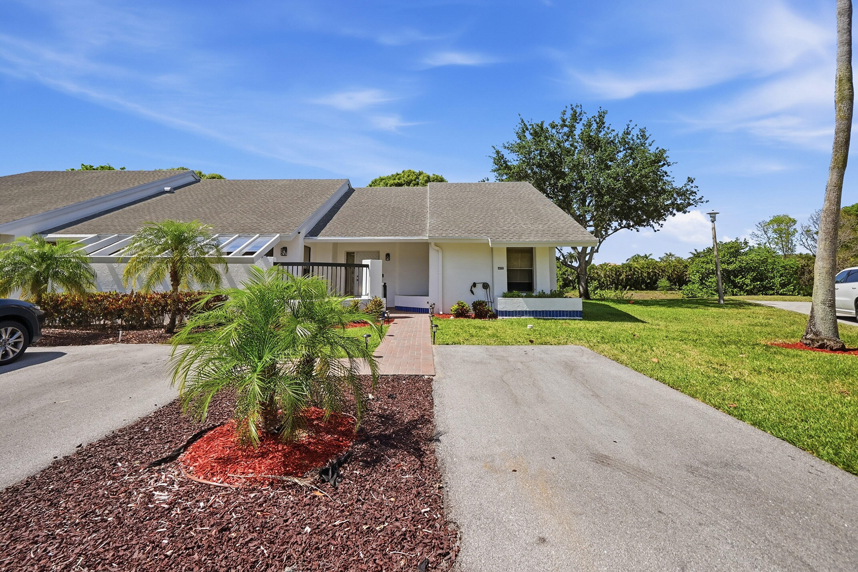 Impeccably maintained villa on a cul-de-sac in gated 55+ community. Waterfront location, maximum privacy; no rear or side neighbors. Move-in ready, 2024 new roof & gutters w/ leaf screens, 2024 water heater. The gourmet kitchen, (2022), shines w/ modern white cabinetry, quartz counters & SS appliances, while the master suite has upgraded bath & 2 walk-in closets. Upgraded doors, automatic blinds, & blackout shades. Floor plan includes an L shaped living area & laundry room w/ sink. For additional utility, the attic has new blown-in insulation w/ drop-down ladder for extra storage. Enjoy lush landscaping in back yard from a 20-foot-long, glass/screen enclosed Florida room with AC. 2 car parking in front with new electric charging station. Many community amenities, close to shopping/dining