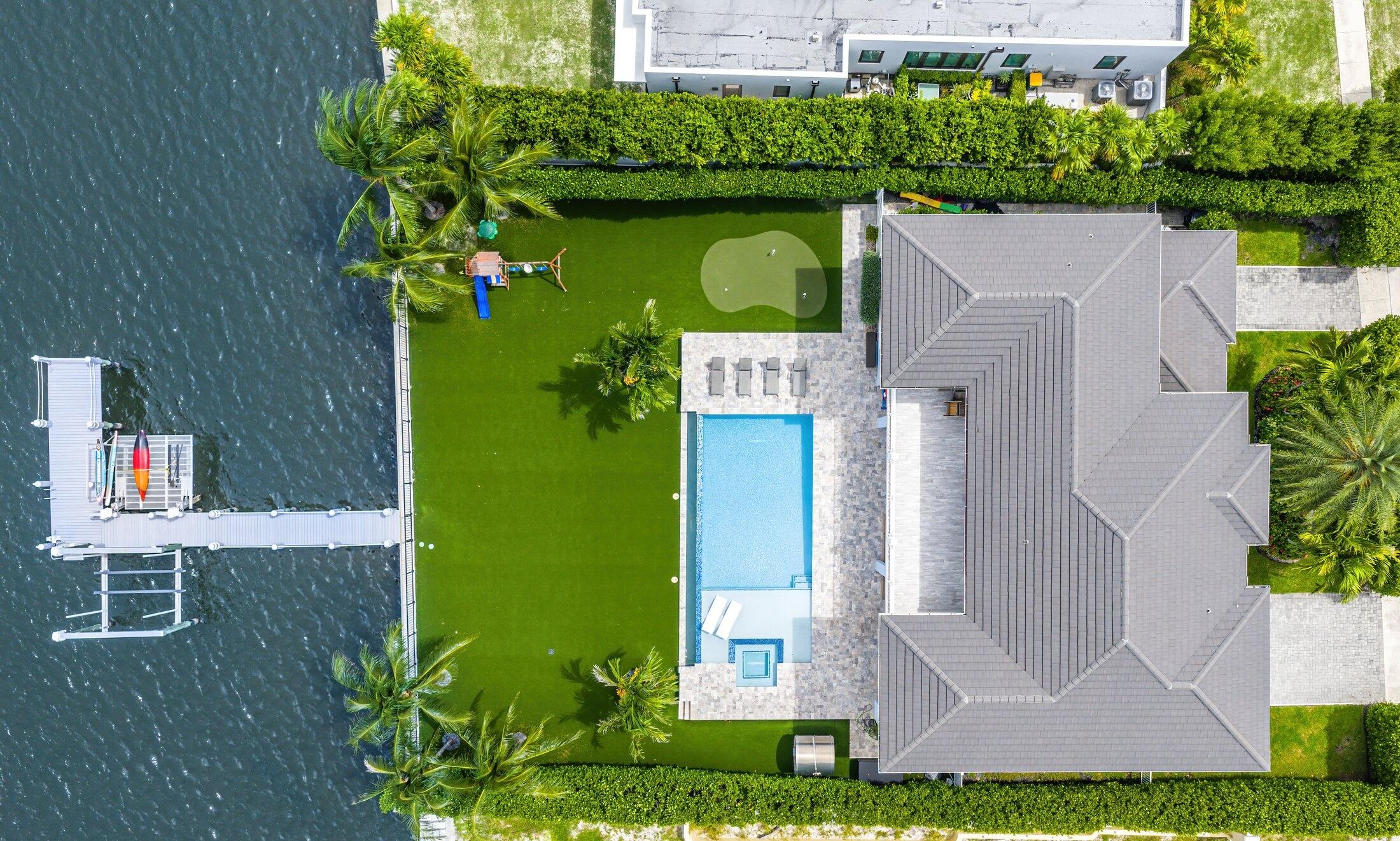 Welcome to this 2017 built, coastal contemporary waterfront estate located on the direct intracoastal in the heart of College Park! This timeless estate offers breathtaking intracoastal views and luxury finishes above and beyond what you expect to find. This trophy property spans two levels and features 5 Bedrooms + a Den/Office, 4.1 Bathrooms, nearly 5,000 Living SqFt, a three (3) car garage, and is nestled on a sizable, 15,000+ SqFt lot. Other notable features that this home offers, include natural gas, a Generac 24kW whole house generator, a fully operational elevator, an extended, composite wood dock, 20,000 lb boat lift, wave-runner lift, artificial turf backyard, and 15' high Clusia hedges for ultimate privacy and peace of mind. Enjoy your private, outdoor oasis with this resort-style backyard, which boasts an enormous 40' x 20' salt-chlorinated and heated pool, a relaxing sun-shelf, a spacious built-in jacuzzi, summer kitchen, and a three hole putting green all to yourself!  The main level features one guest bedroom, a den/office, full bathroom + powder room, and an open concept kitchen overlooking the family room, dining room, and an unmatched views of the intracoastal and backyard. The upstairs features the primary suite, three additional guest bedrooms, two full guest bathrooms, and a laundry room.   The primary suite spans nearly 600 SqFt alone, which includes a palatial bathroom with dual vanities, freestanding bathtub, and an enormous, walk-in shower. In addition, the primary suite also offers a private, covered balcony overlooking the stunning backyard with views of South Palm Beach Island and even the Atlantic Ocean.  College Park is just a stone's throw away from the highly coveted Flager Drive and less than a 10 minute drive from the reimagined Downtown WPB, which features countless new restaurants, retail shops, eateries, and so much more. West Palm Beach has seen a surge of new development with luxury waterfront condo projects like South Flagler House by Related Ross, the 28-story Shorecrest, Olara residences, Nautilus 220, and the latest development, The Berkeley Palm Beach, all adding high-end living options to the skyline.   This comes alongside a boom of restaurants, retail, and entertainment destinations downtown, including Eataly at CityPlace, Estiatorio Milos, Harry's Bar & Restaurant, a New York staple, cocktail lounge Mary Lou's, Tacos Del Cartel, and breakfast standouts like H&H Bagels in the nearby NORA District adding to the city's growing reputation as one of South Florida's most vibrant food and lifestyle hubs.
