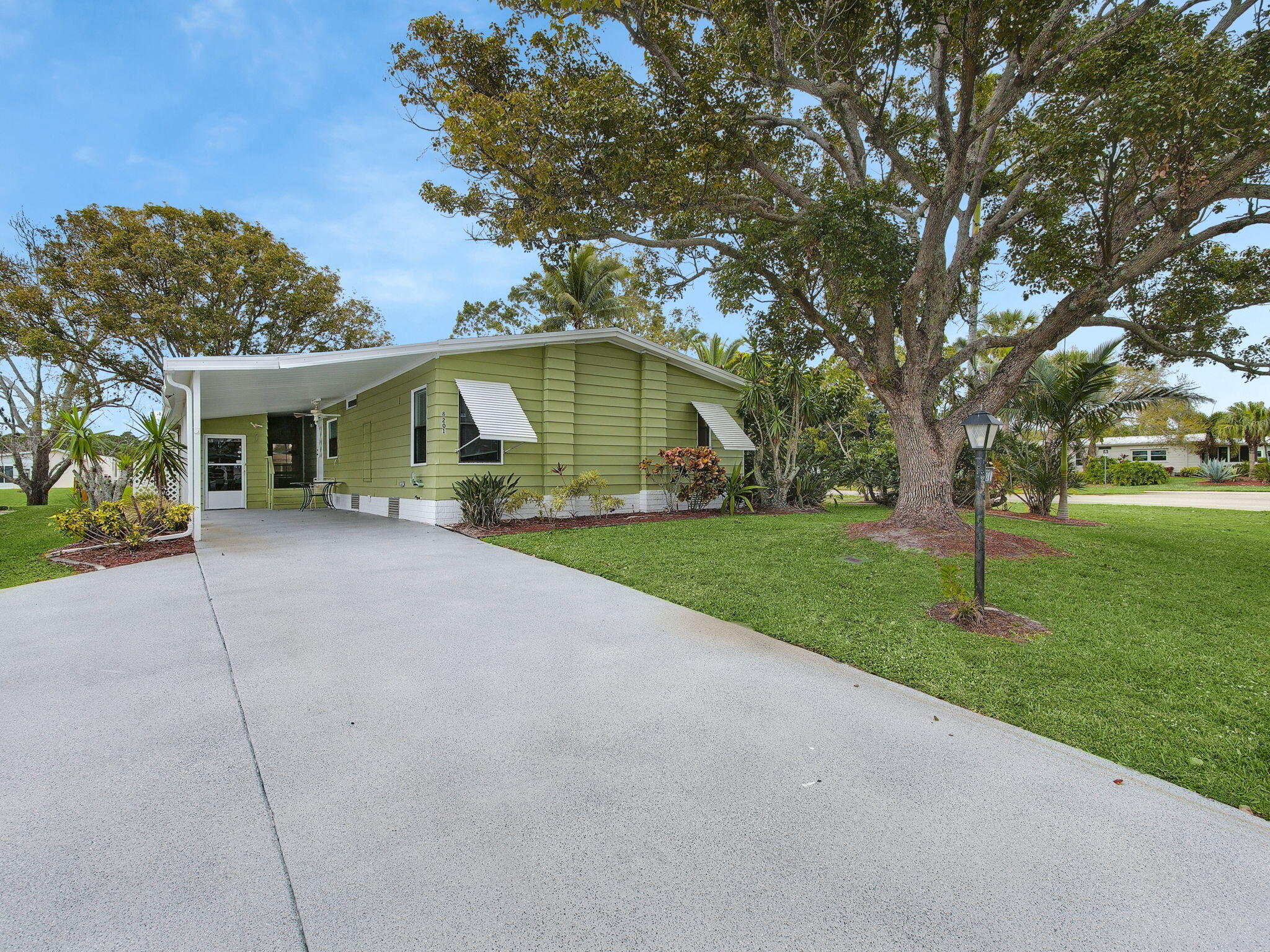 Welcome Home to this charming LAND OWNED 2/2 with a 2020 roof, large carport, large workshop, and 20 extra tie downs for peace of mind.  Corner waterfront lot with an enclosed patio.  Large master bedroom, open floor plan, and a giant bonus room with a view of the lake.  This home does not disappoint.  Enjoy an active resort lifestyle in Savanna Club which offers 18-hole golf course, theater w/live entertainment, tennis, volleyball, pickleball, shuffleboard, bocce, horseshoes, indoor basketball, 3 pools, classes, and clubs.