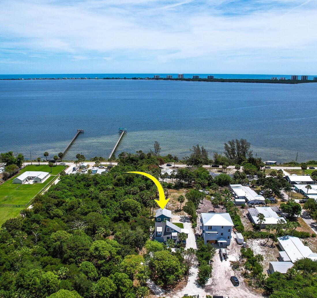 Private, secluded setting overlooking the intracoastal with serene water views, beautiful sunrises, and steady coastal breezes. This three-story property features 4 bedrooms and 2 bathrooms on nearly half an acre, providing privacy and flexibility for a variety of uses.  The home has been recently renovated with impact windows and doors on the first and second floors, new decking, updated landscaping, and a new gravel driveway. The kitchen includes granite countertops, wood cabinetry, and new stainless steel appliances. Additional improvements include a newer septic system and water system,  Interior features include wood flooring in the main living areas, fresh interior and exterior paint, newly renovated bathrooms and new kitchen appliances. Multiple porches provide functional outdoor living space with direct water views.  The property includes a detached two-car garage and offers a high level of privacy.  No HOA. Ideal as a primary residence, second home, or investment property with strong short-term rental potential. You wont find another home with such charm and character in all of South Florida!