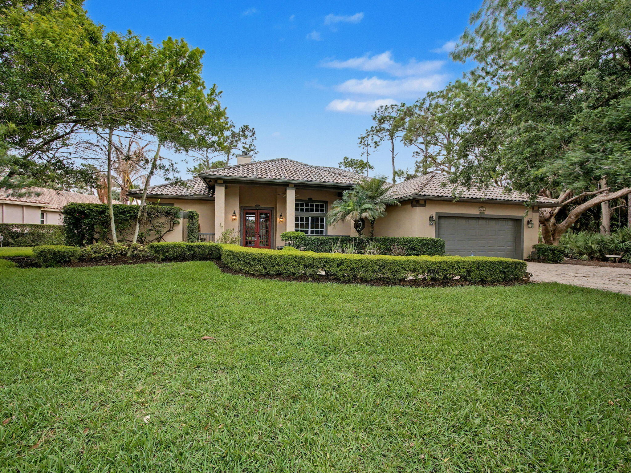 Located within the gated waterfront community of Locks Landing in the desirable Windship Estates section, this beautifully maintained 4-bedroom, 3-bath residence with a 2-car garage offers a rare combination of privacy, elegance, and lakeside serenity. Framed by mature landscaping and a large paver driveway with extra parking, the home makes a welcoming first impression before you even step inside. The thoughtfully designed interior features 11-foot ceilings, an open and airy layout, and refined architectural details throughout. Formal living and dining rooms showcase extensive decorative moldings, while a double-sided fireplace shared between the living room and the main suite adds warmth and character to both spaces. The chef's gourmet kitchen is appointed with rich wood cabinetry, a  center island, walk-in pantry, and opens seamlessly to the breakfast area highlighted by a dramatic butted glass window overlooking the lake. The spacious main suite serves as a private retreat and includes a large spa-like bath with double vanities, a soaking garden tub, separate water closet, and a generous walk-in closet. Three additional guest bedrooms provide flexibility for family, visitors, or workspace needs, including one bedroom with a private exterior entrance ideal for guests or multigenerational living. The upgraded guest bath features quality wood cabinetry and double sinks, and a convenient cabana bath offers easy access for future outdoor entertaining or pool use. Set on a secluded lot with mature landscaping and spectacular lake views, the backyard offers exceptional privacy and plenty of room to design a custom pool and outdoor living space. Residents of Locks Landing enjoy 60 private deeded ocean-access docks, a private boat ramp, and boat trailer storage. A beautiful lifestyle opportunity in a naturally wooded setting just minutes from shopping, dining, schools, and major highways for easy commuting.