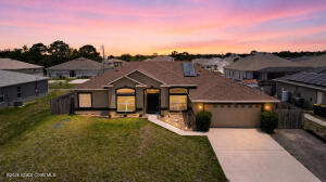 Step into a beautifully upgraded, move-in ready home in the heart of SW Palm Bay--designed for comfort, efficiency, and modern living. This spacious open floorplan features 3 bedrooms, 2 bathrooms, plus TWO versatile flex rooms--perfect for a home office, gym, playroom, or guest space--so everyone can enjoy their own retreat. Enjoy peace of mind with a roof just 3 years old, energy-efficient A/C system, a solar water heater and solar attic exhaust fans that help keep utility costs low. The extended driveway adds extra convenience, while oversized hurricane-impact windows enhance both safety and natural light. Front windows are finished with energy-saving, privacy UV film for added comfort.  Inside, you'll love the newer luxury vinyl plank flooring throughout, fresh interior and exterior paint, and updated lighting fixtures that give the home a clean, modern feel. The kitchen is a standout, featuring oversized premium cabinetry that offers abundant storage and style for everyday living and entertaining  Step outside to a large fenced backyard--ideal for pets, gatherings, or simply relaxing in your own private space.  Located in one of Palm Bay's fastest-growing areas, this home offers easy access to top-rated schools, shopping, dining, and everyday conveniences--all within an established, welcoming neighborhood.  This home truly checks all the boxes--schedule your private tour today and see it for yourself!