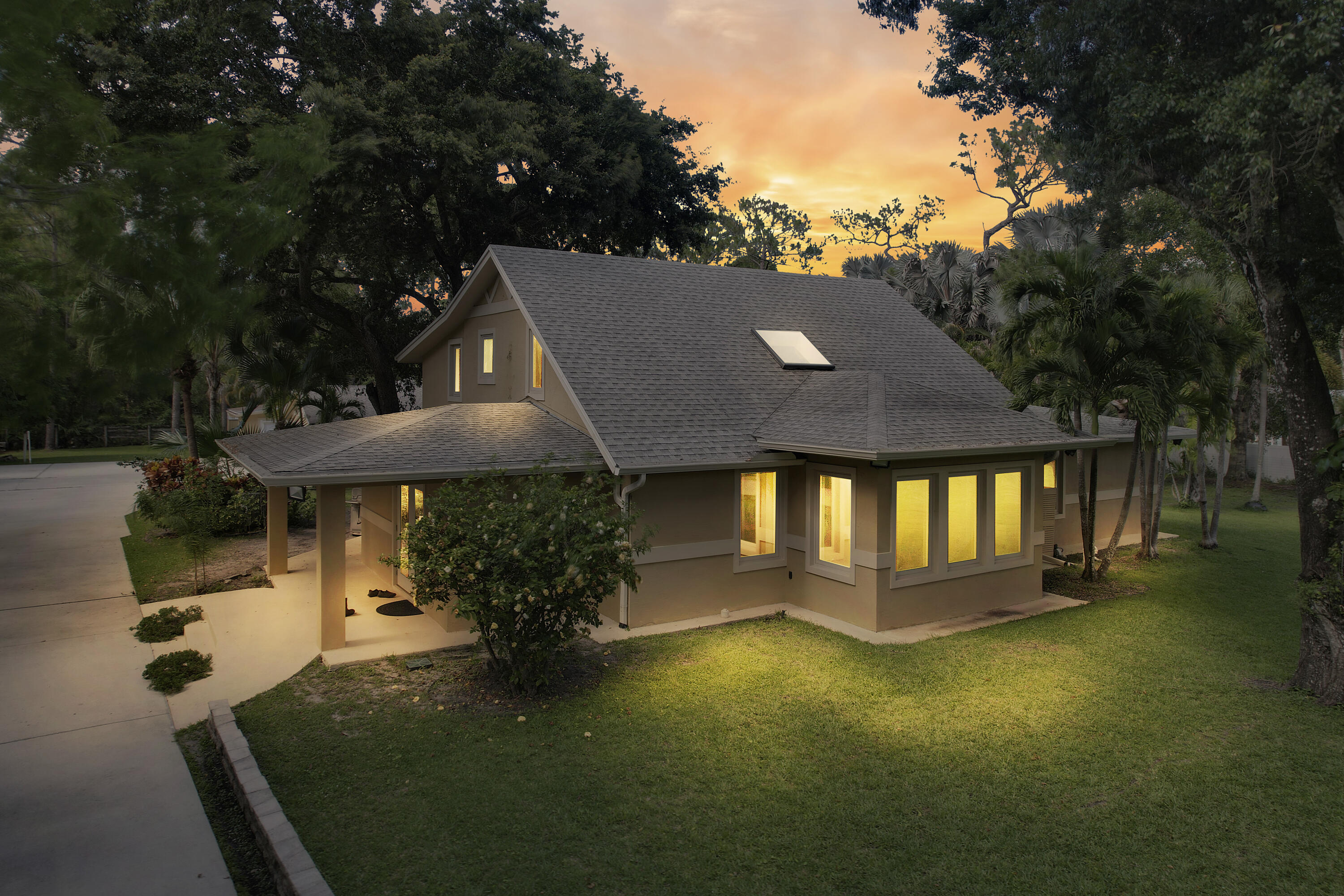 Rare fully renovated 2-building estate on a high and dry 1.14-acre fenced lot on a paved road in Jupiter Farms. Custom 2014 CBS-rebuilt fortress with concrete-filled, steel-reinforced walls, spray foam insulation, underground power, and full hurricane-impact protection. Main home offers 4BR/2.5BA, soaring ceilings, bamboo floors, oversized skylights, chef's kitchen with Italian marble, and luxury primary suite with granite shower. Detached 2023-built guest cottage/executive suite includes full bath and private sauna. 2024 AC units. Features include 400-amp service, covered patio, outdoor shower, oversized outdoor stainless steel spa, mature landscaping, fruit trees, and room for a pool or additional garage. Seller has survey, wind mitigation, and 4-point inspection available upon request. Detached guest cottage rebuilt in 2023. Main residence fully rebuilt in 2014 with reinforced CBS construction, impact glass/skylights, spray foam insulation, and underground utilities. Avg electric bill approx. $130-$140/month per seller. High elevation lot; property has 21' of elevation. Room for pool and additional garage structure. Buyer to verify all measurements, uses, zoning, and school information.