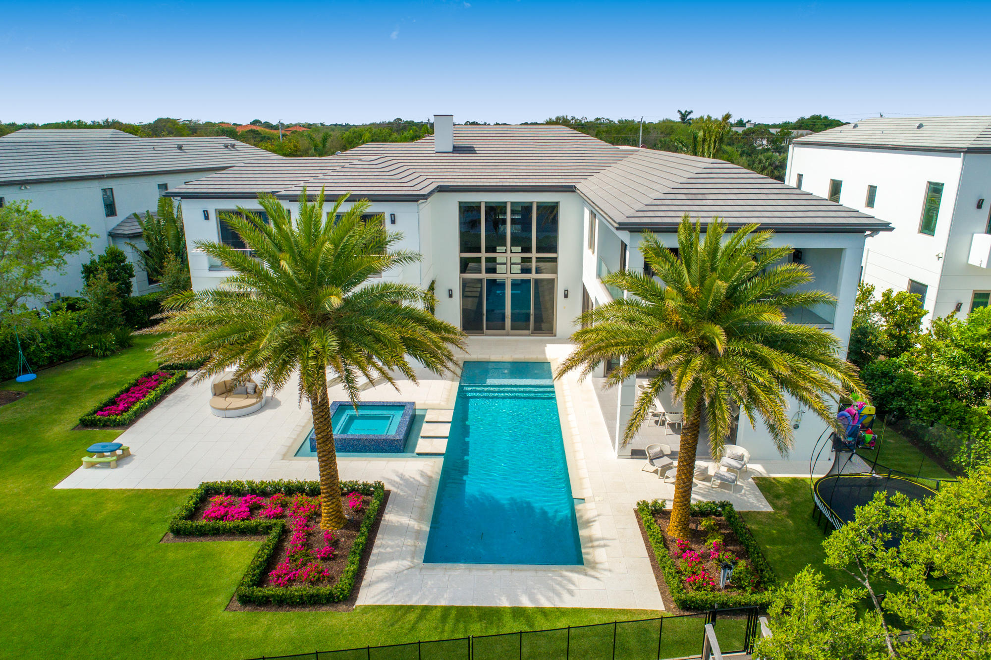 Introducing an exquisitely crafted modern masterpiece located directly on the Intracoastal Waterway, in the highly desirable, private gated enclave of Harbor Place adjacent to The Bears Club in Palm Beach Gardens. Custom designed & built by the most sought-after professionals in South Florida, this is an entertainer’s dream home featuring open concept spaces that seamlessly merge to showcase the sophisticated & refined interiors of this indoor-outdoor living residence. Enjoy 157 ft of direct Intracoastal access with an elevation allowing for total privacy & unobstructed views of the Intracoastal Waterway & the Juno Preserve across the water. The highest quality craftsmanship & finest finishes are reflected in this custom home, designed & built by the award-winning team of ... Couture Lifestyles, Smith & Moore Architects & Pauline Hartogh of Wetherlys Interiors. Boasting almost 10,000 total sq ft, this 6 bedroom residence is complete with all the modern amenities essential for a luxurious lifestyle. The formal living room is designed to perfection with quality finishes, linear 24 ft fireplace & a decorator showstopper. The chef's kitchen offers every culinary convenience with prep kitchen, butler's pantry, top-of-the-line Thermador appliances, 2 over-sized grand islands with all Downsview cabinetry, custom pull out drawers & custom designed Quartz countertops. The 1st floor master suite features a generous walk-in closet & luxurious en-suite bath with beautiful Intracoastal water views. This stunning home features reinforced CBS tie-beam construction, an elevator, optional media/game room, custom solid reclaimed wood front door, electric blinds, marble flooring, designer wall-coverings, impact glass windows & 10ft sliders, whole house generator, plenty of storage, security system, Smart house technology with complete automation from your smartphone, top-of-the-line appliances, designer plumbing fixtures & laundry room with full-size washer & dryer on each floor & much more. Showcasing stunning views of the Intracoastal, the 2nd floor grand master wing is a luxurious retreat with a tranquil sitting area & expansive private covered balcony, morning bar, custom boutique his-and-her closets, en-suite bath with walk-in glass shower, soaking tub & separate water closets. There are 3 additional guest suites on the second floor each with walk-in closets & custom, designer bathrooms. The covered loggia provides boundless room for lounging, relaxing & entertaining around the resort-style heated pool & spa complete with summer kitchen, cabana bath & an outdoor shower. Beautiful beach & long dock with 16,000 lbs boat lift & sitting bench along with Intracoastal waterways. This exceptional location in Palm Beach Gardens in the intimate waterfront community of Harbor Place offers close-proximity to the world class shopping & restaurants of the PGA corridor both by car or boat! The home is minutes away from secluded beaches of Juno & Jupiter & the Jupiter and Palm Beach Inlets.