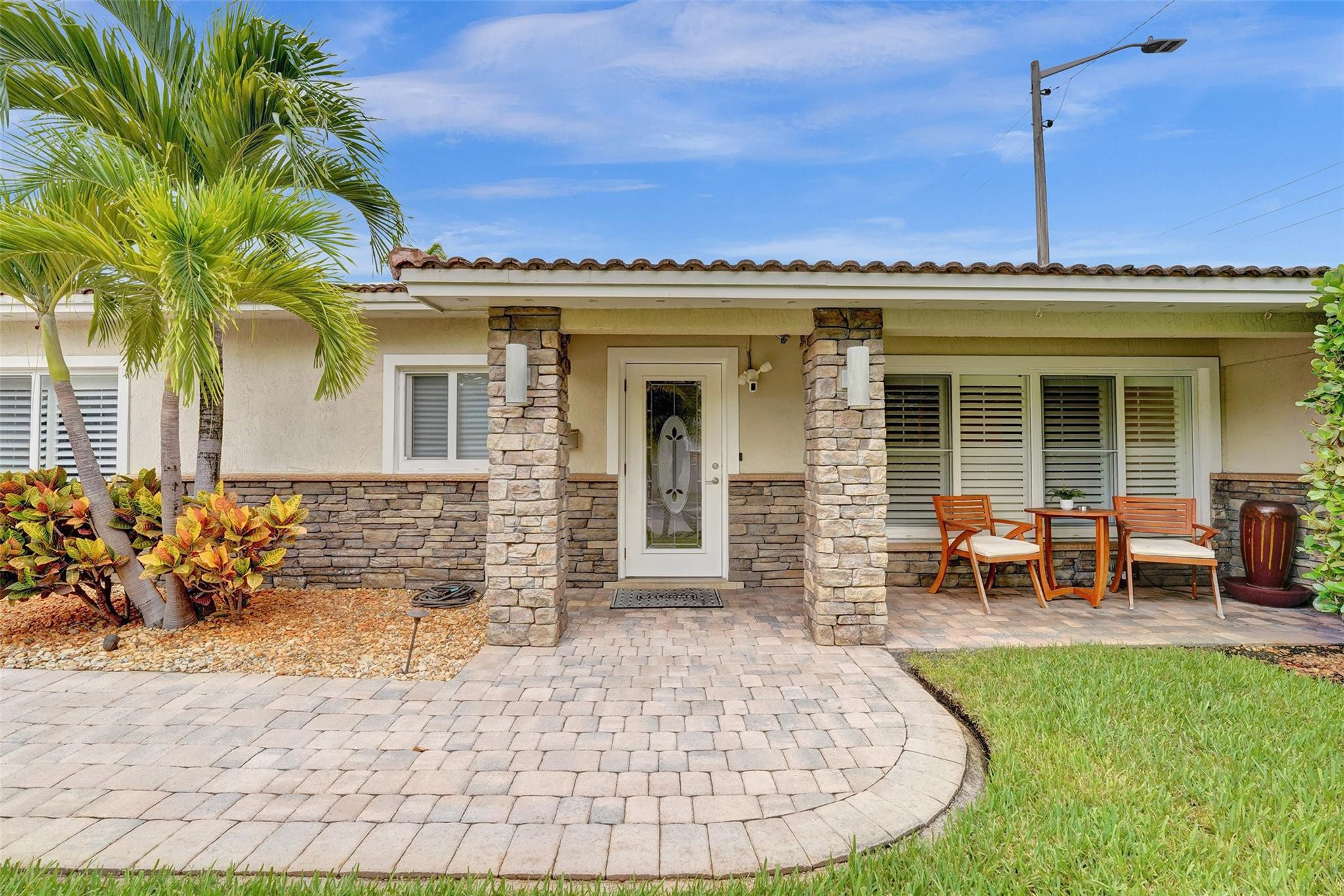 Pristine and exquisitely kept, this Lakeridge home offers ultimate South Florida living minutes from the beach, downtown, and shopping. The open-concept main home features 3 en-suite bedrooms plus a den. An additional attached, private in-law suite includes a separate bedroom, living room, bath, and kitchenette—perfect for guests or rental income. The tropically landscaped, fenced backyard is a private oasis boasting a heated pool, fire pit lounge area, and a custom Tiki hut with a built-in grill and fridge. Premium upgrades include full impact windows/doors, an expansive driveway with an EV charging station, and well sprinklers. Currently a successful vacation rental and can be sold turnkey!