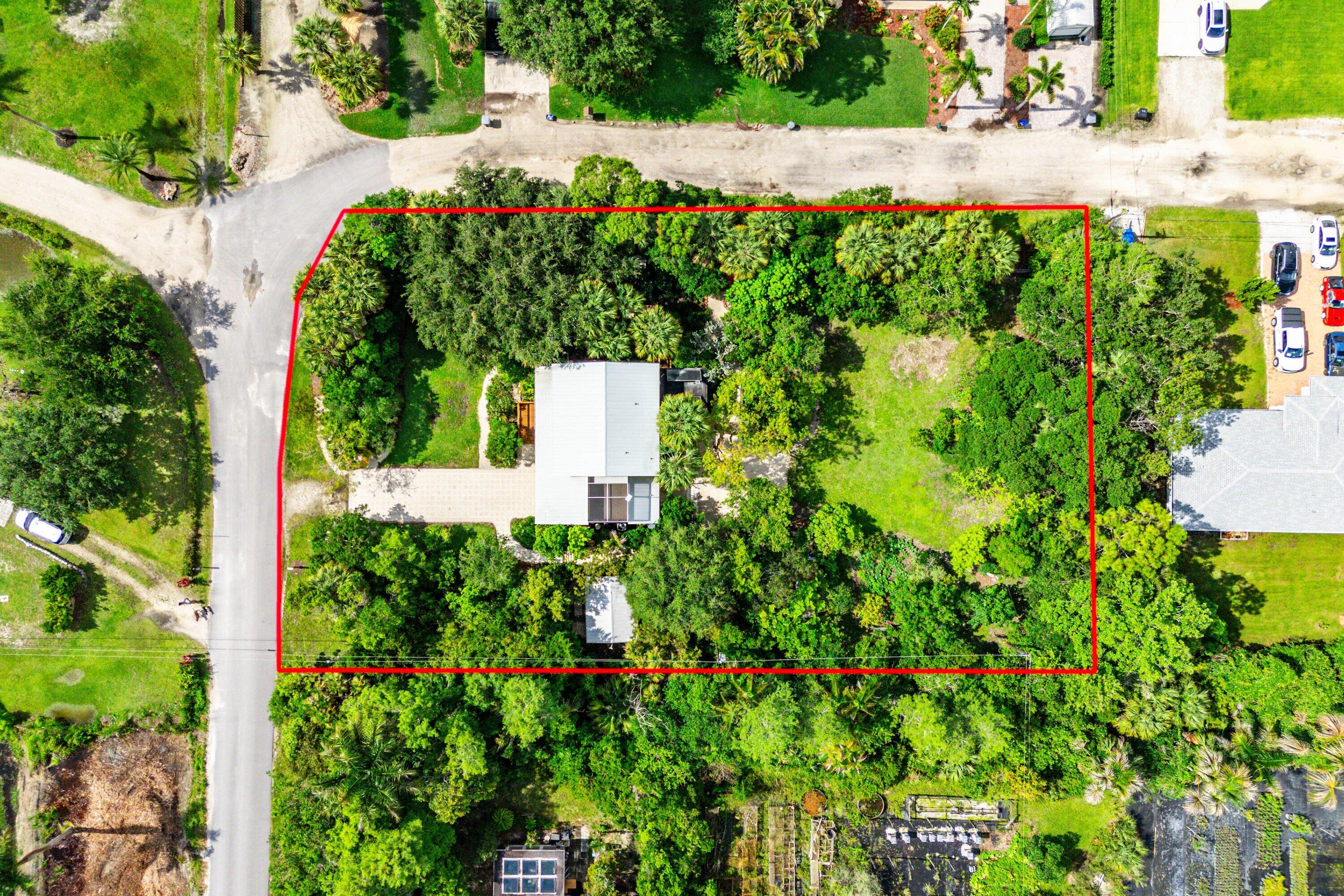 RARE OPPORTUNITY - BEAUTIFUL HOME ON 1 ACRE IN HERITAGE FARMS WITH NO HOA AND SUBDIVISION POTENTIAL! Welcome to your own private botanical garden and wildlife sanctuary in the peaceful community of Heritage Farms. This exceptional .9 acre property includes two platted parcels, offering the rare opportunity to potentially create an additional approximately ½-acre buildable lot. Keep the expansive estate intact or subdivide for a future home, multi-generational living, or investment opportunity. Originally envisioned as an equestrian community, Heritage Farms remains a quiet rural enclave west of 441 while still being conveniently close to shopping, dining, and city amenities. Zoned AR, the neighborhood embraces a unique blend of residential living and small-scale agriculture...  The property itself is truly extraordinary, featuring over 220 SPECIES OF NATIVE FLORIDA PLANTS AND TREES thoughtfully designed to mimic natural ecosystems. Mature specimens include Sabal Palms, Live Oaks, Gumbo Limbo, Silver Palms, Bald Cypress, Lignum Vitae, and many more species. Fruit trees such as mango, avocado, banana, and mulberry provide both beauty and bounty and appropriate non-native plants include Firespike and Bull-hoof, Jamaican Lily Tree Panama Rose and others.  Chemical-free and very low-maintenance, this landscape creates a thriving habitat for butterflies, hummingbirds, wild parrots, Screech owls, Barred owls and other wildlife. The beautifully maintained 4-bedroom, 3.5-bath two-story home was fully renovated in 2007 and offers flexible living space throughout. Neutral ceramic tile flooring throughout and oak hardwood stairs.  Spacious eat in kitchen with granite counter tops, wood cabinets, pantry and gas range.  New Maytag W/D.   Upstairs features three bedrooms including the primary suite, while downstairs includes a spacious bedroom with private entrance and full bath—ideal as a guest suite, in-law quarters, or first-floor primary suite. A dedicated den/office provides additional versatility.    BUILT FOR DURABILITY AND EFFECIENCY, THE HOME INCLUDES:  **IMPACT WINDOWS AND DOORS  **METAL ROOF   ** SOLAR 120 GALLON HOT WATER HEATER • HIGH-EFFICIENCY 18 SEER VARIABLE SPEED AC (2 YRS OLD)  **ICYNENE INSULATION THROUGHOUT ATTIC AND HOME PROVIDES VALUABLE ENERGY EFFICIENCY.    Relax and enjoy nature from the screened wood porch, upstairs screened balcony, or peaceful patio overlooking the pond with waterfall and firepit. The fenced backyard includes four access gates, a detached workshop with electricity, chicken coop (with option to include four chickens), and plenty of room for RVs, boats, a pool, or detached garage. Horses and farm animals are welcome. Located in a highly A rated school district with Coral Reef Elementary, Woodlands Middle, and Joaquin Garcia High School, and just minutes from nearby nature destinations including Walker Preserve and the renowned Arthur R. Marshall Loxahatchee National Wildlife Refuge. A VERY UNIQUE ONE-OF-A-KIND South Florida property where privacy, nature, flexibility, and building opportunity with investment potential come together!