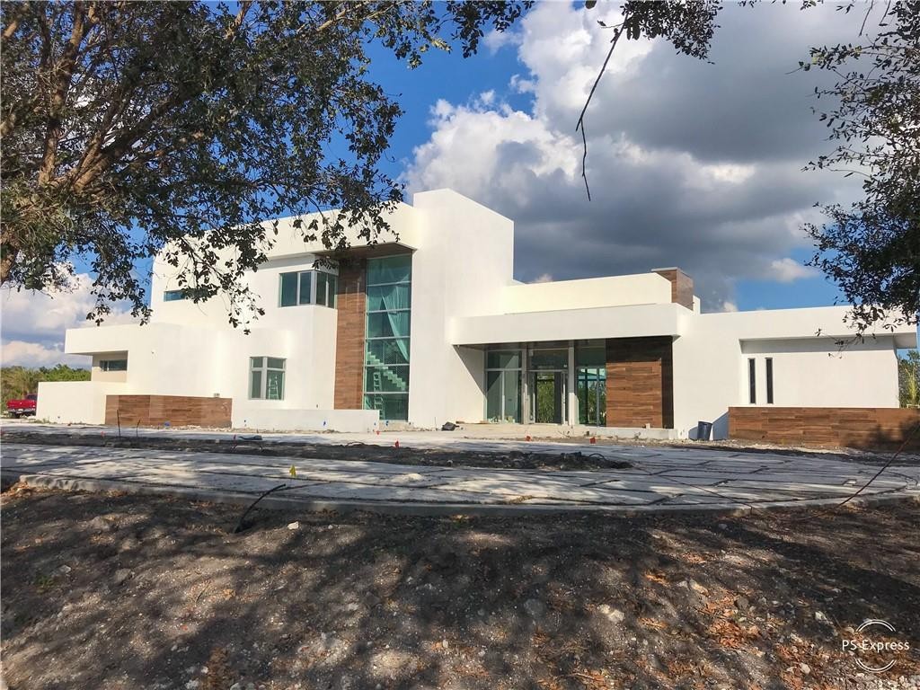 ***MODERN LUXURY MEETS SUNSHINE RANCHES!!!*** MAGNIFICENT MODERN MASTERPIECE DESIGNED AND CONSTRUCTED FOR TODAY'S SOUTH FLORIDA LIFESTYLE. COMBINING NEARLY 14,000 SQFT OF LUXURY. THE MAIN HOUSE REPRESENTS 5 BEDROOMS,5 FULL BATHS,POWDER ROOM,OFFICE,GAME ROOM,THEATER,GYM AND 6 GARAGES,WITH AN ATTACHED GUEST HOUSE CONSISTING OF 2 BEDROOMS, 1 FULL BATH, KITCHEN, LIVING ROOM AND CABANA BATH. SOARING 19 FT CEILINGS AS YOU ENTER W/12 FT CEILINGS THROUGH-OUT. UNIQUE AND IMPRESSIVE 4 CAR GARAGE W/GLASS DOORS, VISIBLE FROM INSIDE TO DISPLAY YOUR CAR COLLECTION. FLOOR PLAN IS PERFECTLY BALANCED, EXPANSIVE ENTERTAINING AREAS,FABULOUS CONTEMPORARY KITCHEN &FINISHES. REMARKABLE ULTRA-LUXURIOUS MASTER SUITE WITH SITTING AREA, HIS/HER BATHS &CLOSETS W/BALCONY. MATURE OAKS ENCOMPASSING THE ENTIRE PROPERTY.