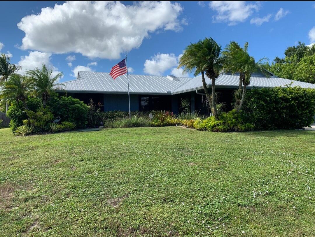 Welcome to your own private Florida paradise! This beautifully maintained coastal-inspired ranch offers the perfect blend of tropical outdoor living and warm interior charm. Featuring a durable metal roof, lush landscaping, soaring ceilings, wood-look flooring, and a stunning stacked-stone accent wall, this home was designed for comfort and entertaining. The spacious kitchen includes granite countertops, stainless steel appliances, custom cabinetry, and a large center island overlooking the expansive screened lanai. Enjoy multiple outdoor seating areas surrounded by tropical palms, creating the ultimate indoor-outdoor Florida lifestyle. More details coming soon!