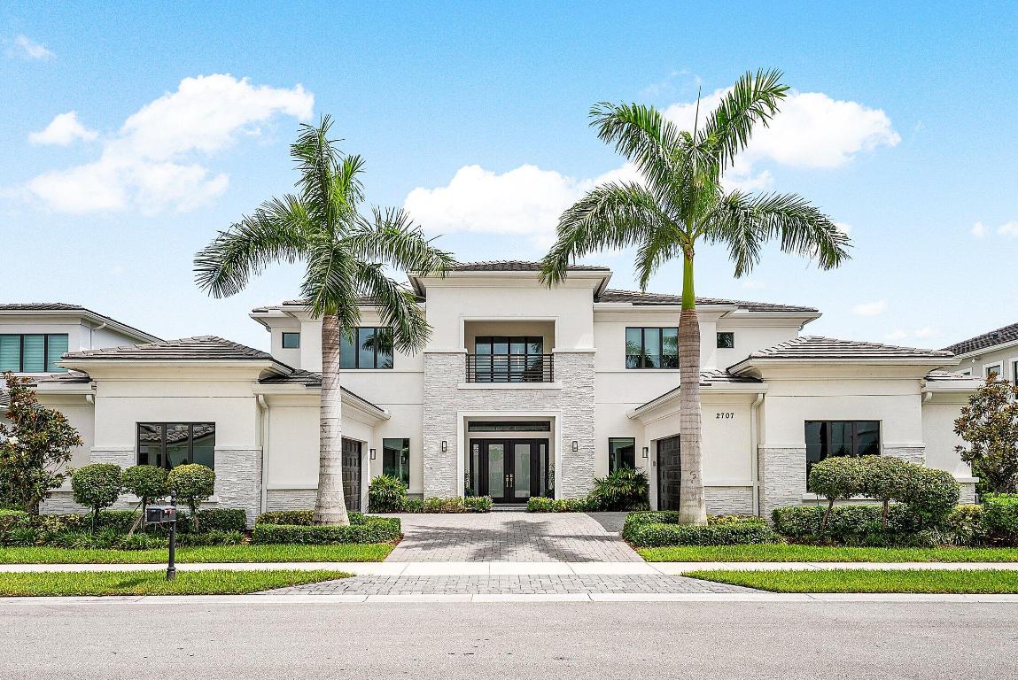 Welcome to 2707 NW 75th Street, a newly built 2022 residence, located in the heart of Boca Raton's exclusive Royal Palm Polo. This stunning home, thoughtfully crafted with high-end finishes and exceptional details, offers the ultimate in luxury living with sophisticated design and well-planned spaces both inside and out. Upon entry, a dramatic double wrought iron staircase sets the stage for the grand interior. Thirty-six-inch porcelain tile floors flow through the main living areas, complemented by custom light fixtures, impact glass, and architectural millwork.
The chef's kitchen is a showpiece with leathered quartzite countertops, Wolf appliances, a Sub-Zero refrigerator, built-in coffee machine, pot filler, wine fridge, and a spacious walk-in pantry.
The first floor hosts an an oversized primary suite with dual walk-in closets and a large sitting area all with herring bone laid wood floors. The primary bath features a large soaking tub and a double shower.  An additional en-suite bedroom, private office, full cabana bath, and powder room complete the level. Upstairs, a loft and another 3 en-suite bedrooms provide flexible living space. Engineered hardwood floors in primary bedroom, office, guest suite and throughout the 2nd floor.
Every element of this home has been carefully curated, creating a turnkey living experience where luxury meets comfort.
Other features included such as, a 4-car garage with epoxy flooring, three AC units, central vacuum, and a whole-house generator powered by natural gas.
Step outside to an expansive fenced yard with no rear neighbor ideal for privacy. Porcelain pavers lead to a covered patio with a wood accent ceiling and electric screens, an outdoor wet bar, and a heated saltwater pool with spa. Residents of Royal Palm Polo enjoy an unparalleled non-membership lifestyle with access to resort-style amenities, including a brand-new Residents' Club with six Har-Tru tennis courts, a state-of-the-art fitness center, resort pool with cabanas, a grand social room, playground, and more.
