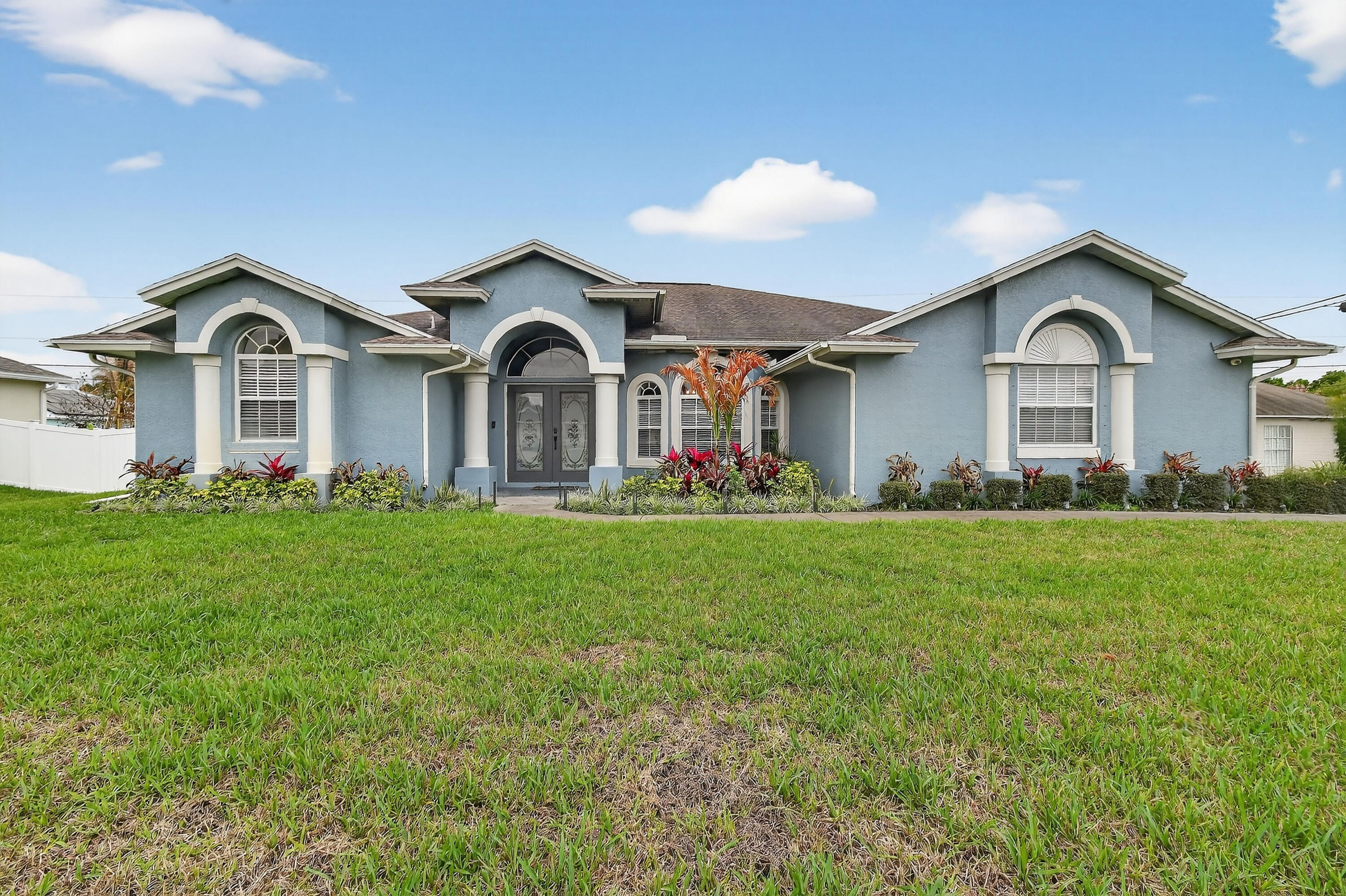 Beautifully updated 3 bed, 2 bath CBS home with a 2 car garage, set on an oversized, fully fenced corner lot. Inside, the kitchen shines with an oversized island that anchors the modern open floor plan, seamlessly connecting the family room, living area, and dining space—ideal for both everyday living and entertaining. The home features uniform 15x30 tile flooring throughout for a sleek, cohesive look. Three sliding glass doors open to a screened patio overlooking a private backyard, creating the perfect spot to relax or host guests.  Additional highlights include a desirable side entry garage that enhances both convenience and curb appeal.  Located between St. Lucie West and Gatlin Blvd, you'll enjoy quick access to shopping, dining, and major highways.