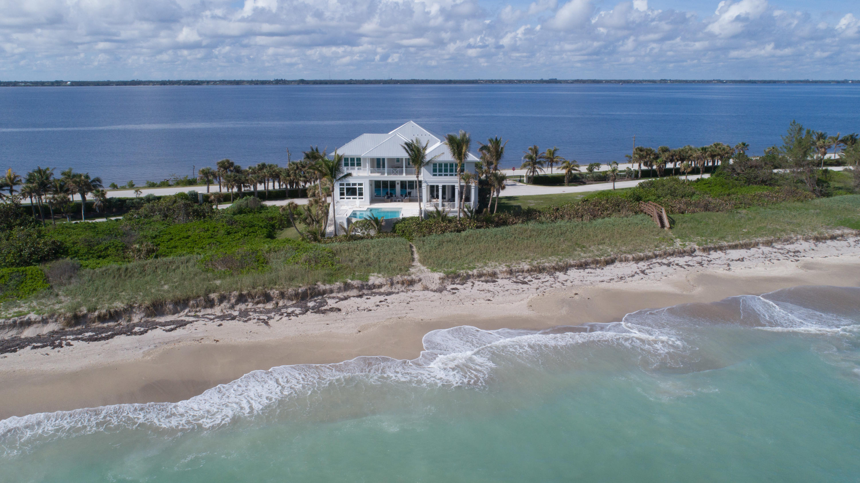 With the ocean as the main attraction, you'll be mesmerized by the irresistible views, as well as unobstructed river views. The interior's design pallet is like an extension of the beach, creating a peaceful aesthetic. High end finishes & rich millwork punctuate the superb craftsmanship and structural integrity. Dream kitchen offers a 6-burner gas cooktop, 2 full-size refrigerators and built-in coffee station. Entertain in the Pub room, the perfect spot to watch TV with the convenience of a full bar. The luxurious master suite has a morning kitchen just outside in the hall. Enjoy the outdoor kitchen, covered lounging areas and infinity edge pool. The garage can accommodate 6+ vehicles and there's plenty of storage throughout the home. This is Coastal Living at its finest!