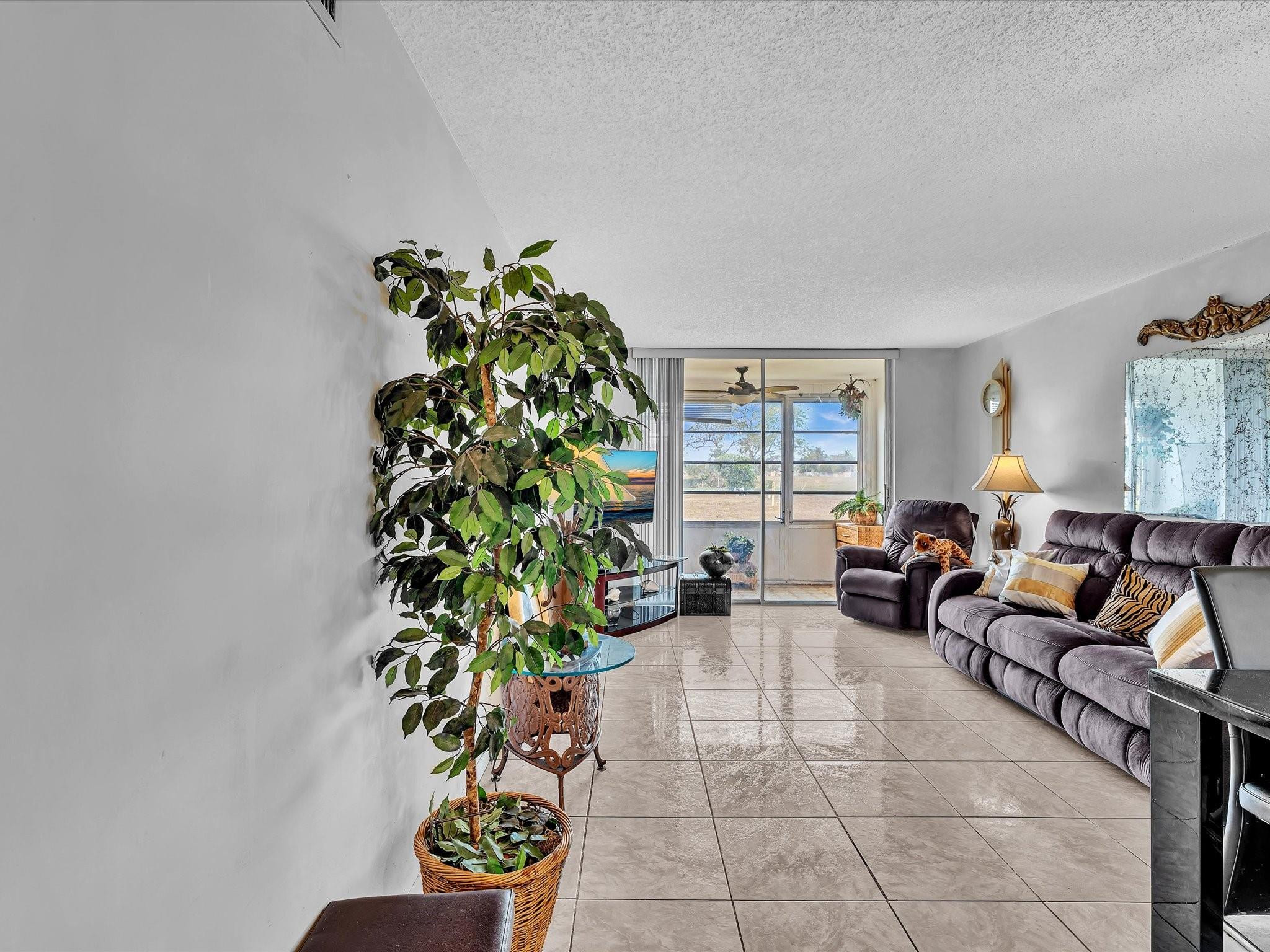 Welcome to this quiet ground-floor end unit with beautiful sunset and canal views in the desirable 55+ community of Sunrise Lakes Phase 3. This light-filled home features a spacious living area, enclosed screened patio, tile flooring throughout, and a primary bedroom with a walk-in closet.The recently remodeled kitchen offers quartz countertops, modern cabinetry, a new sink, range, and refrigerator, complemented by new ceilings with LED lighting for a fresh, contemporary feel.No special assessments. Maintenance includes water, cable, internet, garbage, insurance, and an appliance repair contract. Emotional Support Animals allowed. Enjoy resort-style amenities including golf, indoor and outdoor pools, fitness center, recreation rooms, library, movie theater, 24-hour security and more. Resort-style amenities including golf, indoor and outdoor pools, fitness center, recreation rooms, library, movie theater, 24-hour security, and an active social calendar. Storage on 3rd floor; laundry on 1st floor.