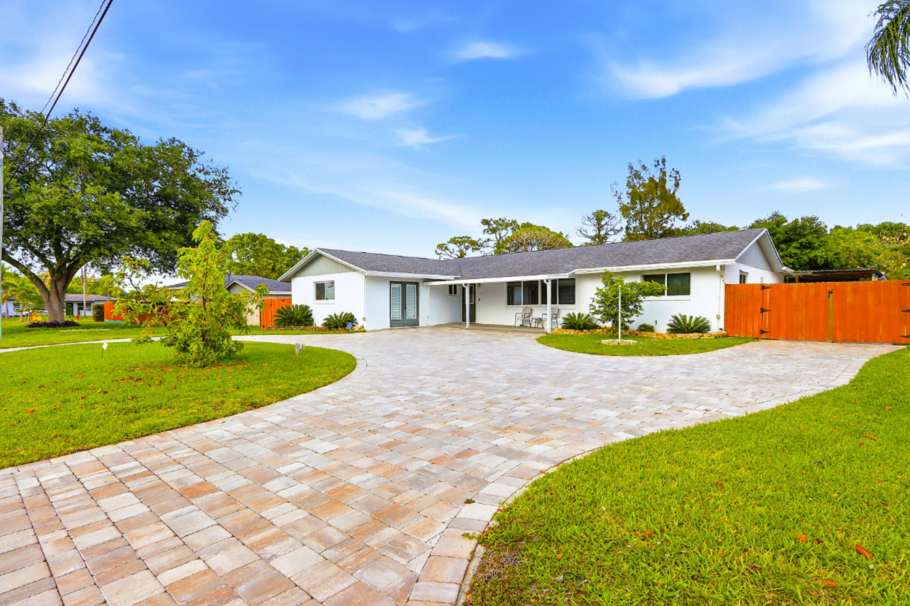 NO HOA! HUGE FULLY FENCED LOT WITH CIRCULAR PAVER DRIVEWAY, GATED SIDE PARKING, DETACHED GARAGE, POOL, GENERATOR & HURRICANE IMPACT PROTECTION! SOME PHOTOS ARE VIRTUALLY STAGED*. Rare fully updated 4BR/2BA West Palm Beach pool home offering 2,296 SF GLA / 2,914 SF GA on a 13,088 SF LOT in a prime central location near I-95, Florida Turnpike, PBI Airport, downtown WPB, beaches, shopping, dining, and major area destinations. Designed for buyers who need more than a standard driveway, this property features a front circular paver driveway, gated side parking, covered private parking, and a detached 12x24 garage/storage building with a commercial-grade roll-down door and commercial-grade shelving on tracks. Plenty of room for RV, boat, trailer, multiple vehicles, work trucks, equipment, tools, or hobby storage. The 4th bedroom/office with separate exterior entry is ideal for a home office, guest space, or flexible-use room. Inside, the home offers a bright split-bedroom/open floor plan with separation between the primary suite and secondary bedrooms, wood-plank-style tile in the main living areas, white kitchen cabinetry, granite countertops, stainless steel appliances, breakfast bar seating, and easy flow to the dining/living areas and pool. Major improvements include a permitted 2017 complete remodel with roof, A/C, hurricane impact windows/doors/sliders, flooring, electrical system, 4th bedroom addition, second bath, and kitchen granite countertops; 2021 kitchen cabinet update, opened kitchen entry, primary bath renovation with dual vanities and modern shower, interior paint, and replaced range; 2022 patio replacement, pool resurfacing, paver driveway, and full-house Generac generator with buried propane tank; 2025 roof over outdoor kitchen area and all HVAC ductwork replaced. FPL electric service is underground, and the primary suite also includes a large walk-in closet. The fully fenced backyard is built for South Florida outdoor living with a sparkling pool, expansive resort-style travertine paver deck, covered lanai, covered outdoor kitchen/BBQ area, fire pit area, and open green space perfect for pets, play, and entertaining. With NO HOA, enjoy the property without HOA pet restrictions, vehicle restrictions, or monthly HOA fees. Prime central West Palm Beach location near Okeechobee Blvd, Southern Blvd, parks, Palm Beach Outlets/Tanger, The Square, Clematis Street, the Norton Museum, and the Kravis Center. Close to notable area educational and cultural institutions, including Bak MSOA, Dreyfoos School of the Arts, Palm Beach Atlantic University, and Vanderbilt University's planned West Palm Beach campus. West Palm Beach continues to attract major investment, development, universities, and financial firms as part of the growing "Wall Street South" movement. *Disclosure: One or more photos have been virtually staged and are labeled accordingly. Virtual staging may include furnishings, décor, artwork, landscaping, vehicles, boats, RVs, outdoor accessories, and other visual enhancements for marketing purposes only. The actual condition, layout, and features of the property are shown in the non-staged photos, which follow or precede each virtually staged photo. Buyers should independently verify all property features, dimensions, permitted uses, and items included in the sale. Information deemed reliable but not guaranteed. Buyer is responsible for independently verifying all property data, including measurements, square footage, and compliance with all city and county ordinances. All information is subject to errors, omissions, or changes without notice. Reliance on unverified information is at Buyer's sole risk.