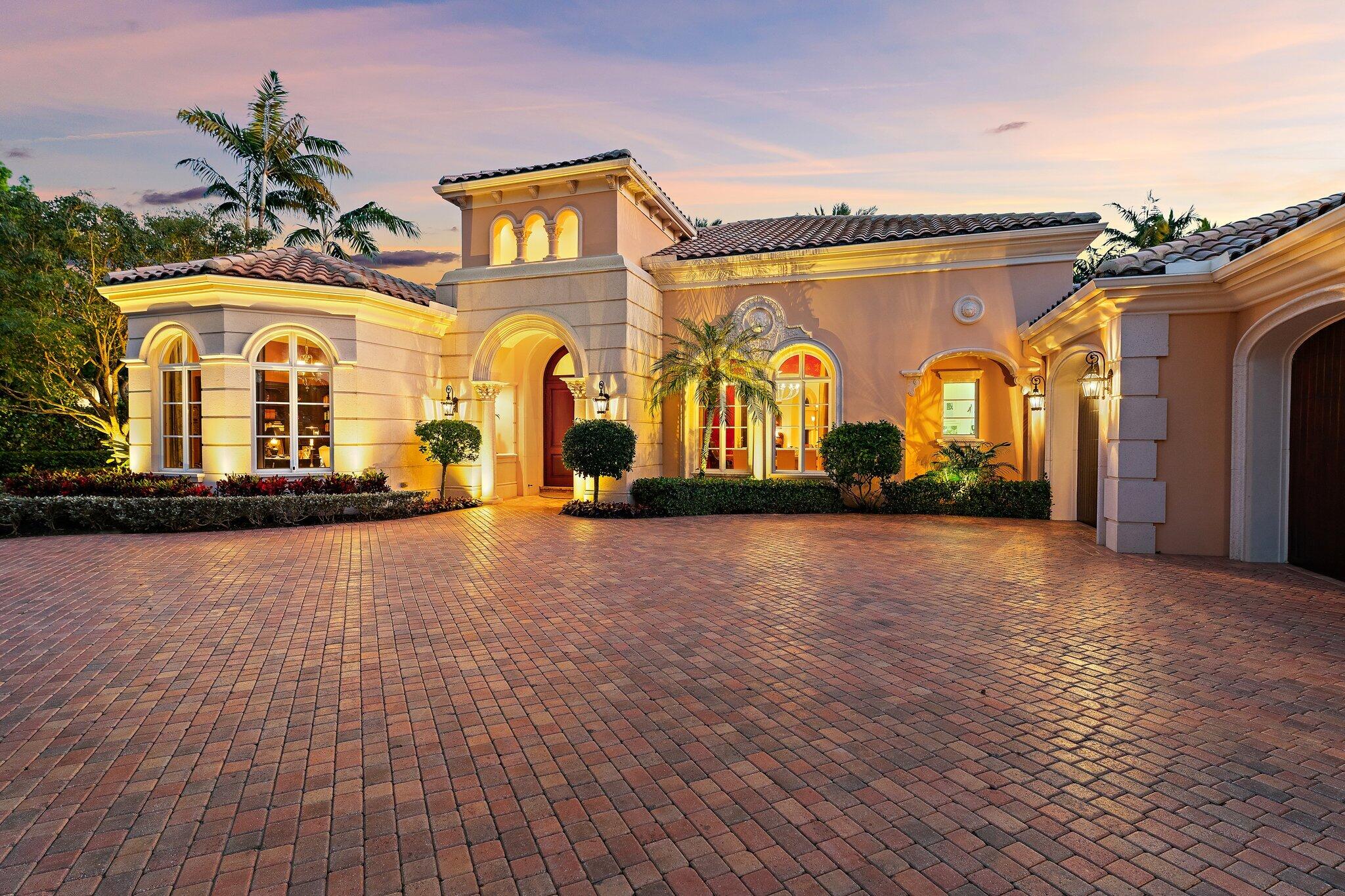Positioned on an expansive, meticulously landscaped nearly half-acre lot in the Grand Estates section of Old Palm, 11756 Elina Court delivers exceptional privacy, elegance, and resort-style outdoor living. Surrounded by mature palms, hibiscus trees, and lush tropical greenery, this residence offers a breathtaking backyard oasis that feels like a private luxury retreat. One of the rare homes in the community where club membership is optional and not required. With almost 5,000 sq. ft. of refined living space, this 4-bedroom, 4.5-bath home plus library features a tri-split floor plan designed for both grand entertaining and serene everyday living. A graceful double-door entry opens to soaring ceilings, elegant architectural details, and a sprawling layout filled with natural light. At the heart of the home is a true chef's kitchen, complete with an oversized island, new Wolf double ovens, gas range, prep sink, long breakfast bar, and an integrated office nook. A casual dining area overlooks the lush backyard, offering the perfect setting for morning coffee with a view. The super-spacious primary suite is positioned to capture serene pool views and features dual walk-in closets and a luxurious spa-style bath. Additional interior highlights include a sophisticated library with stunning bay windows, a grand formal entry, and a living room anchored by a beautiful statement fireplace, creating a warm and inviting centerpiece, with a seamless flow between the living spaces. The backyard is a showpiece, an extraordinary outdoor sanctuary featuring a resort-style pool with spa, waterfalls, and upgraded digital lighting and controls, plus a brand-new pool heater. Expansive lounging and dining areas sit among meticulously designed landscaping for maximum privacy and beauty. A beautifully designed private side courtyard adds a second outdoor living area, with direct access from two guest suites and the family room, ideal for quiet relaxation or a secluded spot to unwind. This home is equipped with a full-house generator, integrated Sonos sound system, and a premium Sony television that conveys. The garage has been elevated with epoxy flooring, custom built-in storage cabinetry, and an air-conditioned storage room for all your extras. Newly re-stained garage doors add to the home's impeccable curb appeal. This stunning property stands as a beautifully maintained estate, showcasing exceptional care and timeless details in an exclusive gated and secure setting within Old Palm Golf Club.