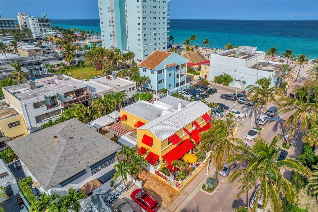 RARE OPPORTUNITY TO ACQUIRE THE PROPERTY AND BUSINESS WITH POSSIBLE 50% SELLER FINANCING!!!OWNER RETIRING.... TURN KEY CASH-COW BUSINESS INCLUDING REAL ESTATE on Hollywood Beach ready for its new owner! Completely stocked and equipped as a boutique style hotel, bar, and hookah lounge! This property includes 6 large furnished suites with full size kitchens and bathrooms and just a few steps away from the beach! Owner made many improvements to the property incl 48 Hurricane impact Windows, 28 Aluminum Bahamian Shutters, 160'Hurricaine Proof Fence, 12 x 12,000 BTU Mini Split A/C units, roof silicone, 4860 SF Travertine Gold Peach Tuscany Pavers, New tile in several suites, New kitchen cabinets & Granite counter, new appliances and much more! REAL ESTATE INCLUDED!!!! ARTWORK IS NOT INCLUDED