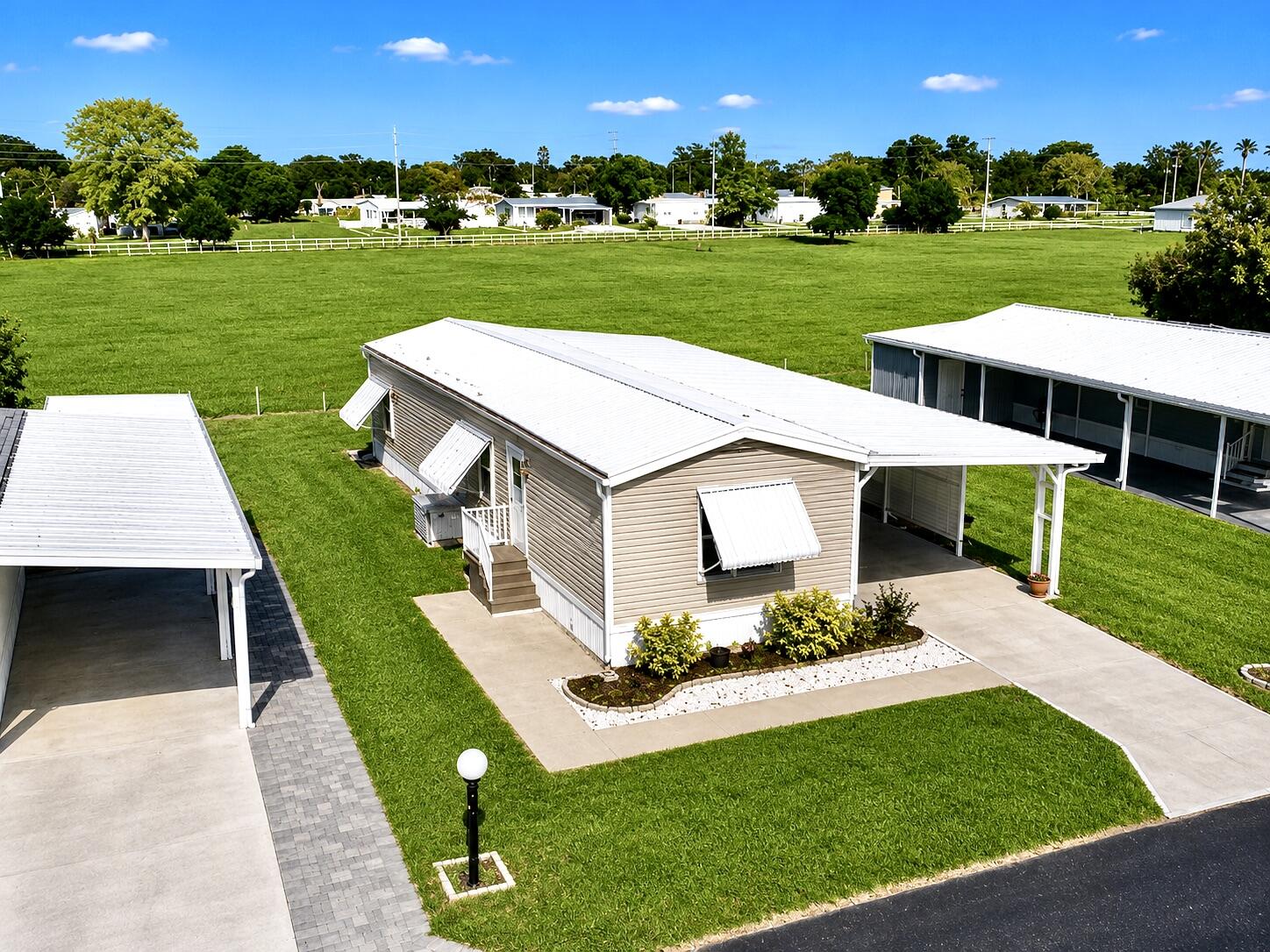 Welcome to Oasis Village, a quiet and well-maintained 55+ community offering comfortable Florida living. Whether it's full-time residence or a seasonal retreat, you're seeking, this well-cared-for, fully furnished 2-bed, 2-bath manufactured home is turnkey and move-in ready! A metal roof, 2022 A/C, vinyl siding, LVP flooring, and plenty of storage in the solid wood kitchen cabinets are some of the upgrades already done. Lots of parking is available with the large 1-car garage-workshop and covered carport that is large enough to park a boat! Relax on the rear patio and enjoy peaceful sunrise views overlooking the open pasture beyond, creating a serene setting rarely found in community living. This home is a true oasis! Residents can take part in the community amenities, including a heated swimming pool, pickleball courts, shuffleboard, and the many social activities and events in the big clubhouse. Trash, pest control for the yard, and lawn mowing are included in the low HOA fee, providing convenience and peace of mind. This gem of a community is conveniently located near shopping, dining, and everyday essentials, and this home offers the perfect combination of comfort and affordability. Schedule your private showing today and discover all that Oasis Village has to offer!