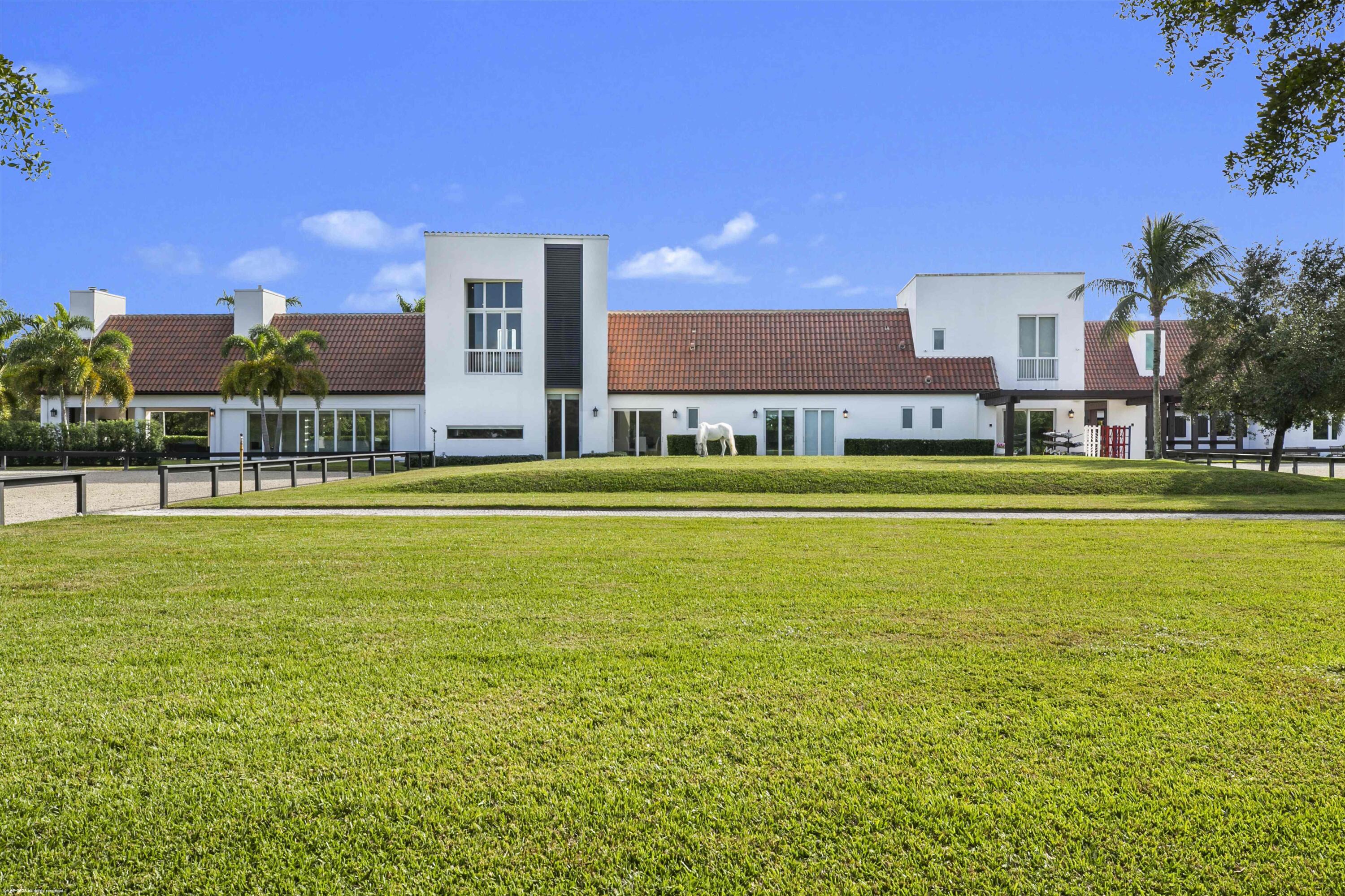 This first-class gated equestrian estate located in Saddle Trail of Wellington, within hacking distance to the show! Enjoy just about a one mile hack to Wellington International all on maintained bridle paths. This all-inclusive property boasts a beautiful and thoughtfully designed 16-stall barn, full equestrian amenities, and a luxurious, designer home, all nestled on over 4 acres in the heart of Wellington's horse country. The stately barn features wide rubber-matted center aisle-ways with 12x12' matted stalls,  2 tack and 2 feed rooms, fly spray system and outdoor grooming areas. There is also a rider's lounge, office and 2 full bathrooms. There are 2 all-weather riding arenas, a round pen and 8 grass paddocks.  Property has city water.  Seller financing possibly available The properties modern residence offers stunning marble floors, cathedral tongue and groove ceilings, a grand wood and glass staircase, state-of-the-art finishes throughout, and more. The sprawling home includes a 3-car garage, 4 bedrooms, 5 full and 1 half bathrooms, family room, formal living room with an exquisite fireplace, formal dining room, game room with full bar, and an indoor gym overlooking the pool area. The European-styled chef's kitchen is equipped with Thermador double ovens, steam oven, induction cooktop, oversized refrigerator, wine cooler, coffee maker & an ice maker. Plentiful outdoor living areas include an expansive second floor patio, the perfect place to entertain and enjoy views of the entire property. A spectacular pool area and a covered patio offers a summer kitchen with both gas and charcoal grills and a scenic view of the riding arenas.

House:
6,942 sq ft under air
8,960 sq ft total
4 bedrooms/6 bathrooms