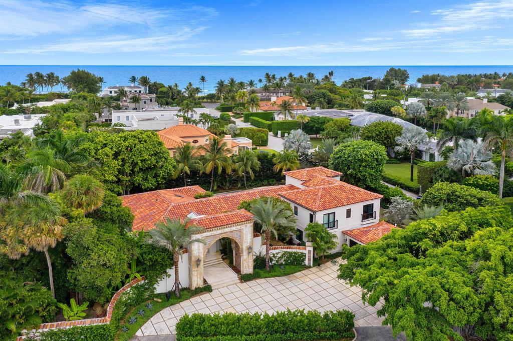 A unique opportunity on the near North End of Palm Beach Island. This substantial Palm Beach residence is a turn-key, move-in ready oasis sitting on an oversized 24,400 + square foot lot. The formal entrance to this recognizable home features the historic Fatio tiled arch, which was originally derived from the iconic Stotesbury Estate, ''El Mirasol''. Steps from private beach access and with prime entry to the Lake Trail, you can bike or walk through one of the most beautiful tree-lined parts of Palm Beach Island, or conveniently drive into town in less than 1 minute. This home was recently reimagined, expanded, and completely renovated to achieve a special balance of contemporary and elegant features, thoughtfully curated with an extreme attention to detail. Some of the most recent improvements include a property-wide landscaping overhaul, physical and digital security additions, and updates to the pool such as modernizing the salt system and adding a remote control iAquaLink, allowing residents to control the pool dynamics seamlessly from anywhere in the home - or anywhere in the world. The chef's kitchen features top-of-the line appliances and a large wine cooler. Walking through the home, you'll enjoy 12 foot vaulted ceilings downstairs and 11.5ft ceilings upstairs. Skylights enhance the abundant natural light throughout the home. A generator adds an additional layer of comfort if needed. The Master Suite functions as its own wing with expansive his and hers walk-in closets, an oversized his and hers Master bathroom, and a generous sitting room with floor to ceiling views out to the heated pool.