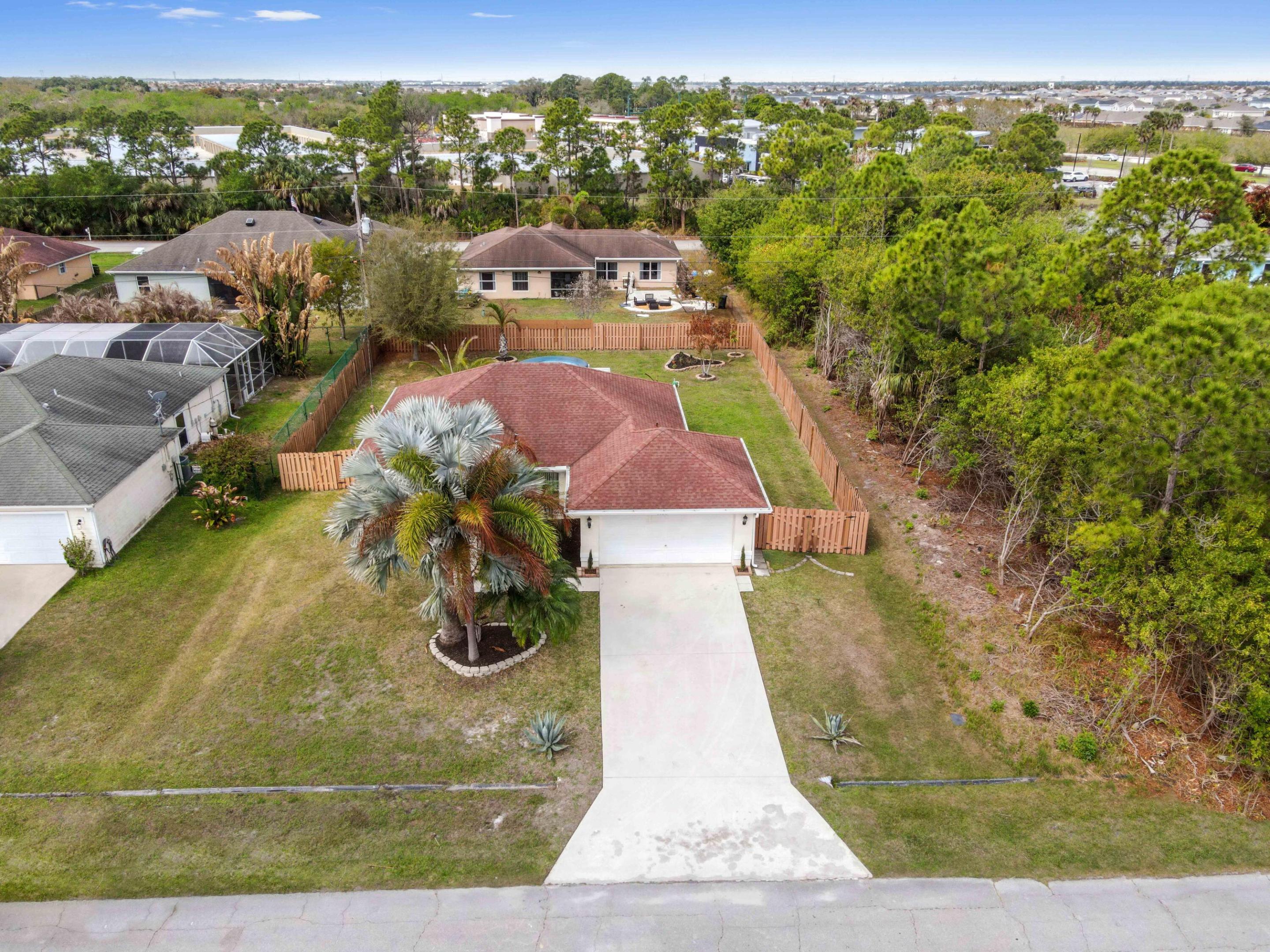 Welcome to this charming 1-story home in Port St. Lucie with no HOA, offering comfort and flexibility. This residence features 3 bedrooms and 2 bathrooms with a welcoming foyer that leads into the dining and living areas. The kitchen showcases tile flooring, a countertop with a faucet and bar seating, and a layout that flows easily into the main living space, perfect for everyday living or entertaining.  All bedrooms are carpeted for added comfort. The washer and dryer are conveniently located in the garage. Step outside to a screened patio overlooking the open, fenced backyard, providing plenty of space for outdoor activities.  A great opportunity to enjoy relaxed Florida living with no HOA restrictions in desirable Port St. Lucie.