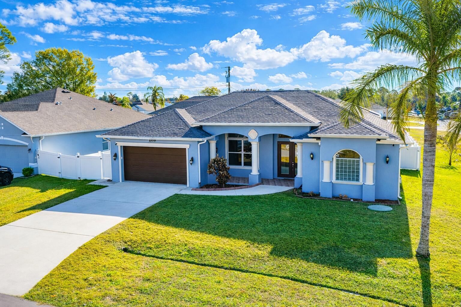 Step into this meticulously maintained 2006 CBS built home situated on a prime .26 acre corner lot. This expansive 4 bedroom, 3 bathroom home features over 2,300 square feet of bright living space defined by soaring vaulted ceilings and a fresh, neutral interior palette. The open-concept layout flows seamlessly from the formal living and dining areas into a chef-inspired kitchen equipped with sleek granite countertops and stainless steel appliances. Retreat to the private master suite, which offers spacious ''his and hers'' closets and a spa-like bathroom complete with a Roman tub and separate glass shower. Recent structural updates provide total peace of mind, including a brand-new roof and gutters installed in 2024. MORE...> , the fully fenced backyard serves as a private oasis with lush tropical landscaping and a covered lanai perfect for evening relaxation. Perfectly positioned for modern living, this home is minutes from the Crosstown Parkway for easy commuting via I-95 or the Turnpike, and offers quick access to the NY Mets Clover Park and top-rated local schools.